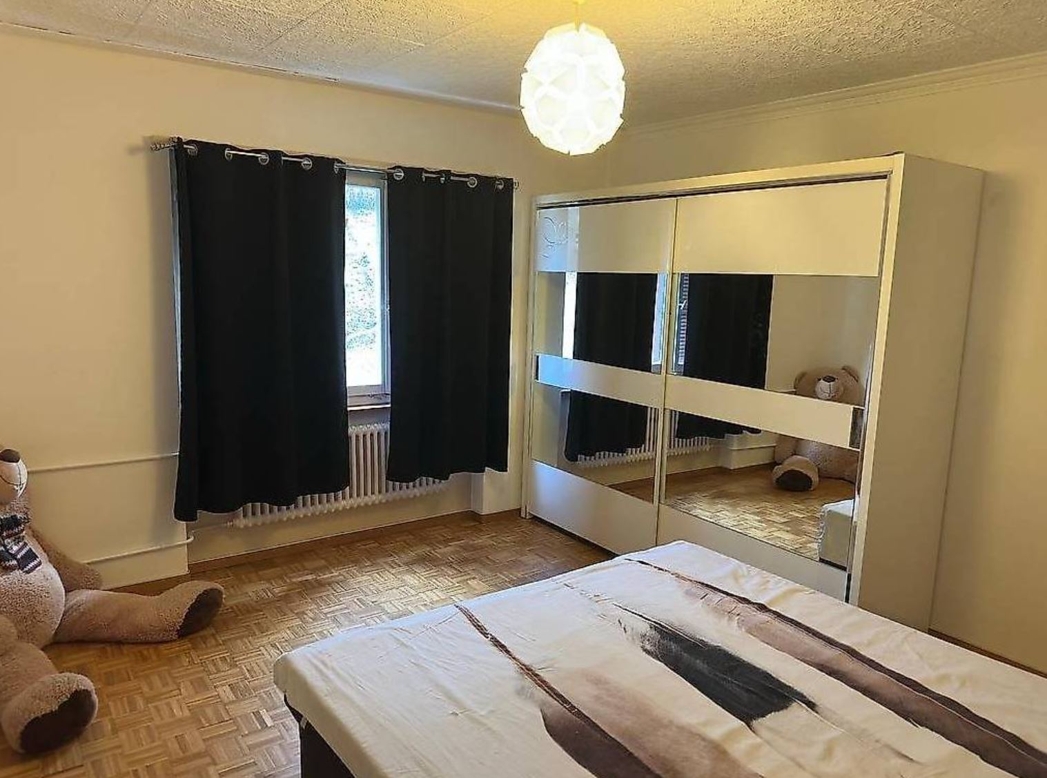Schlafzimmer mit Kleiderschrank und Teddy