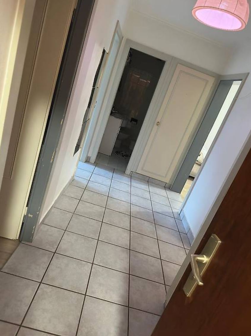 Flur mit gefliesten Boden und mehreren Türen