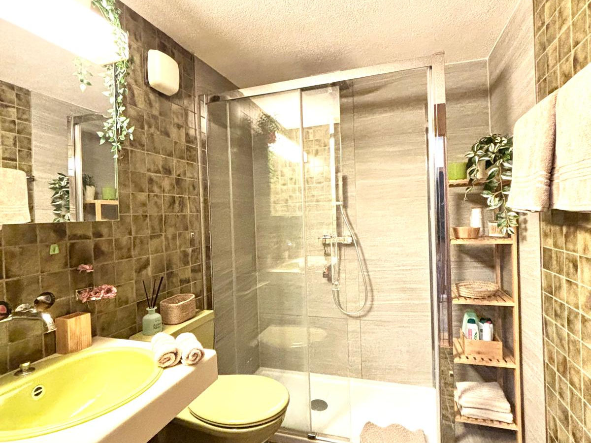 Badezimmer mit begehbarer Dusche und warmen Naturtönen