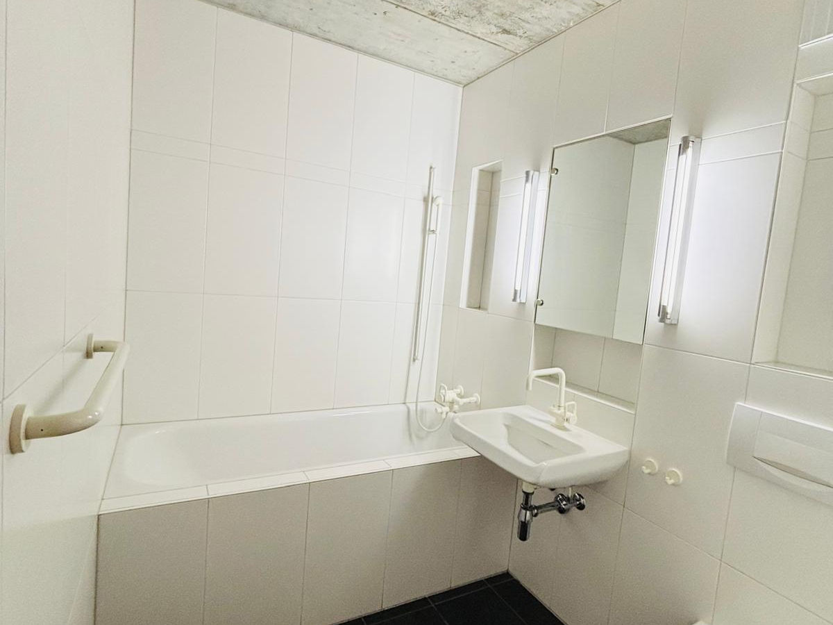 Kleines helles Badezimmer mit Wanne und Spiegeln