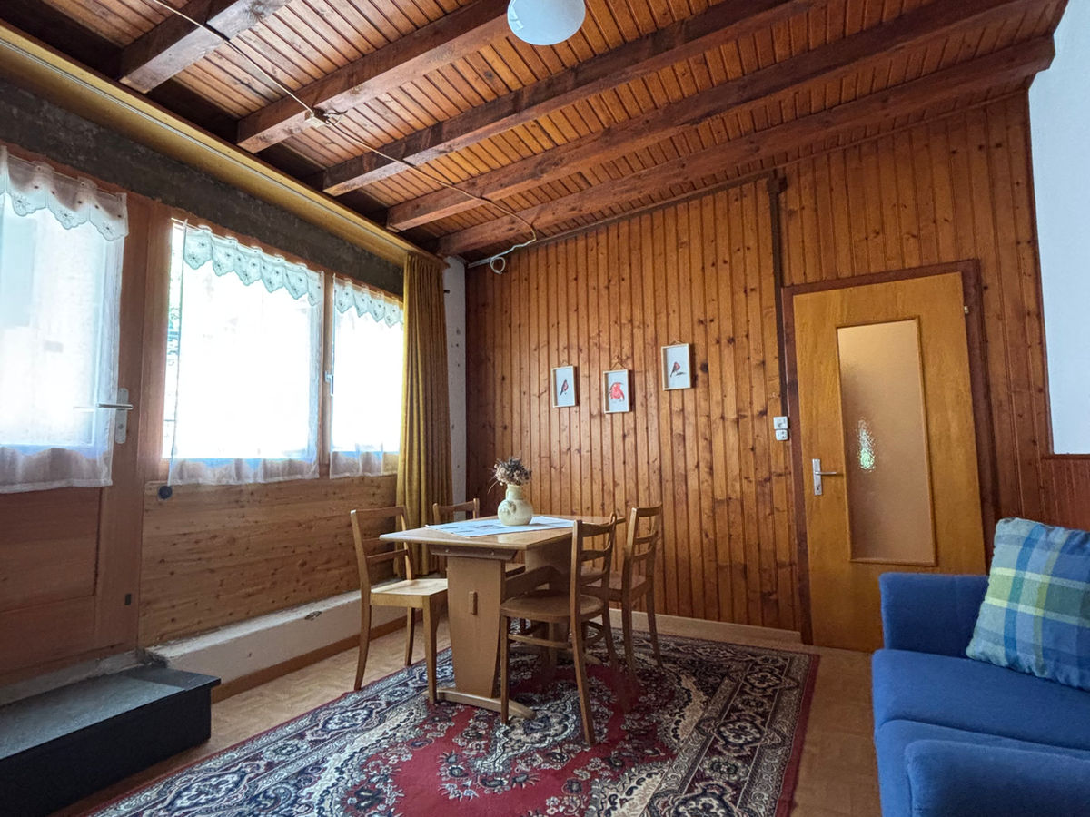 Gemütlicher Holzwohnraum mit Esstisch und Sofa