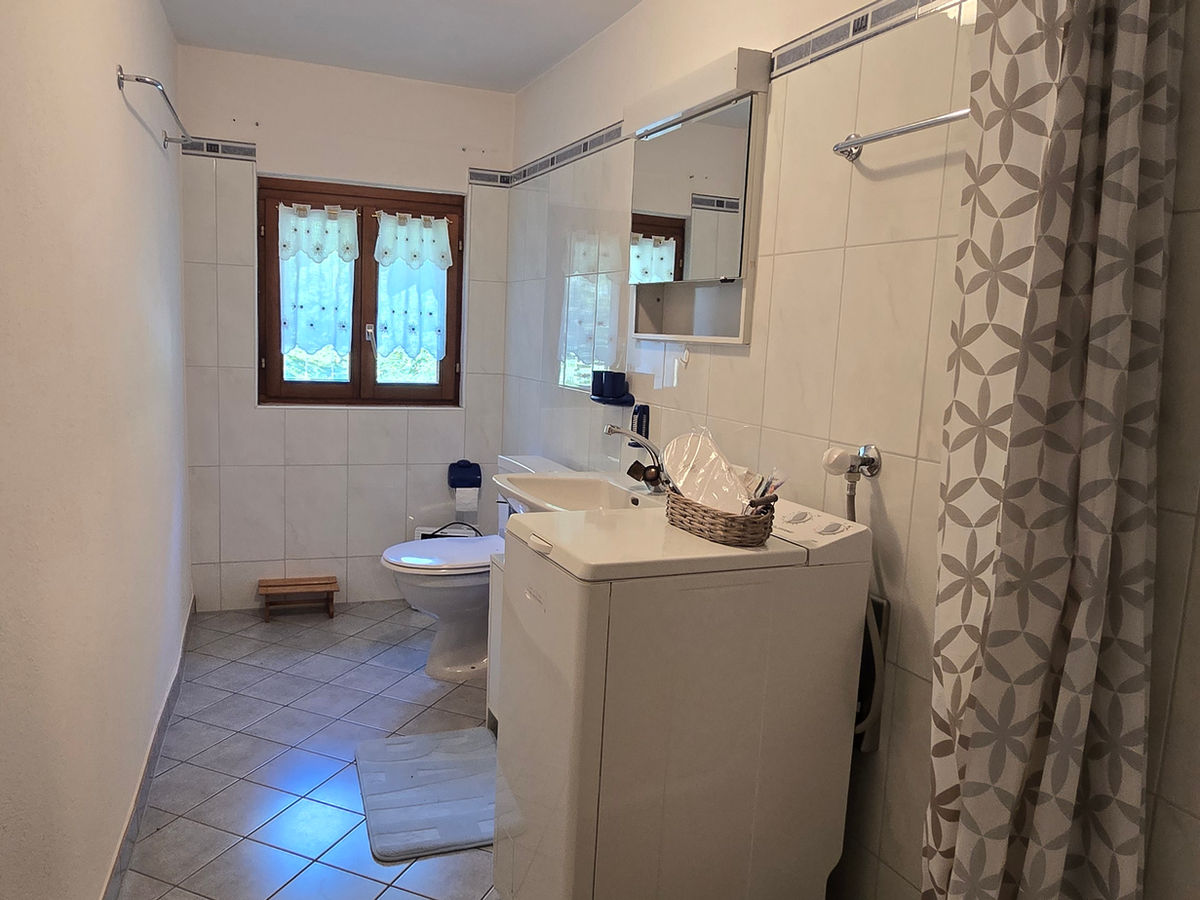 Badezimmer mit Fenster und Waschmaschine