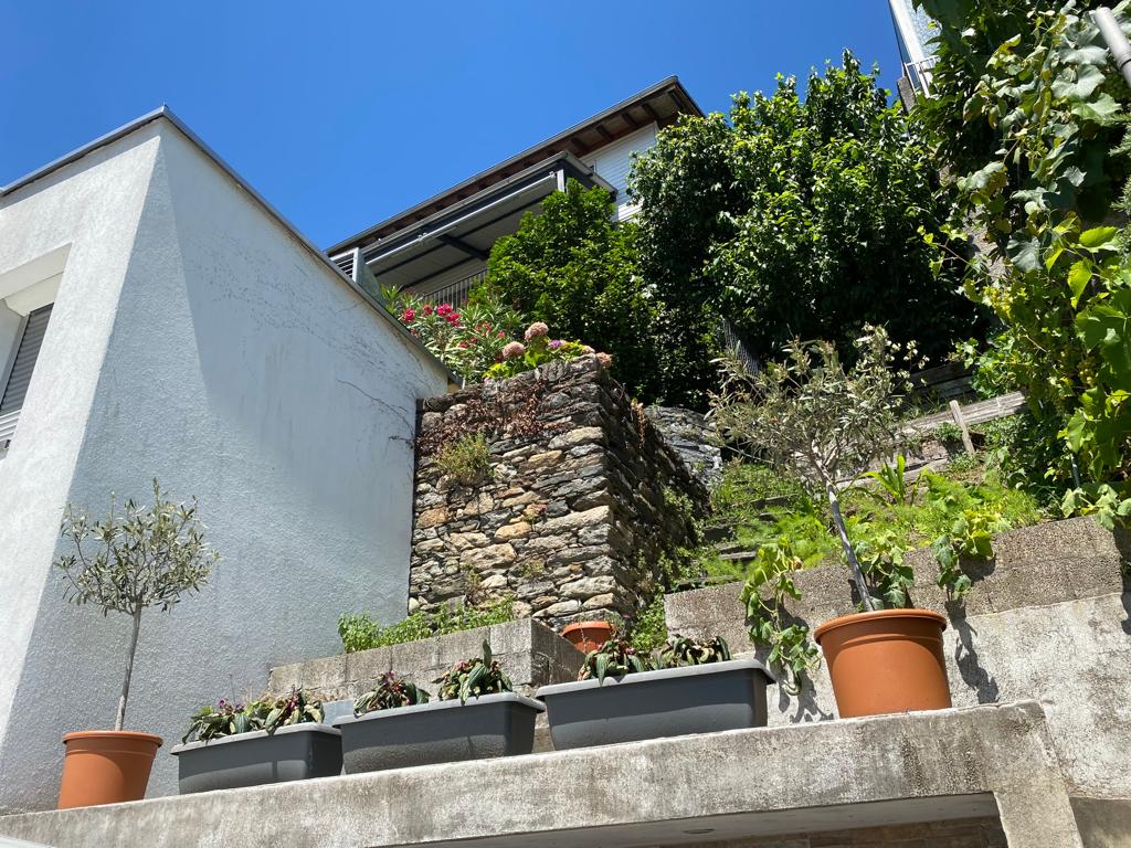 Außenansicht eines terrassierten Hauses mit Gartenhang