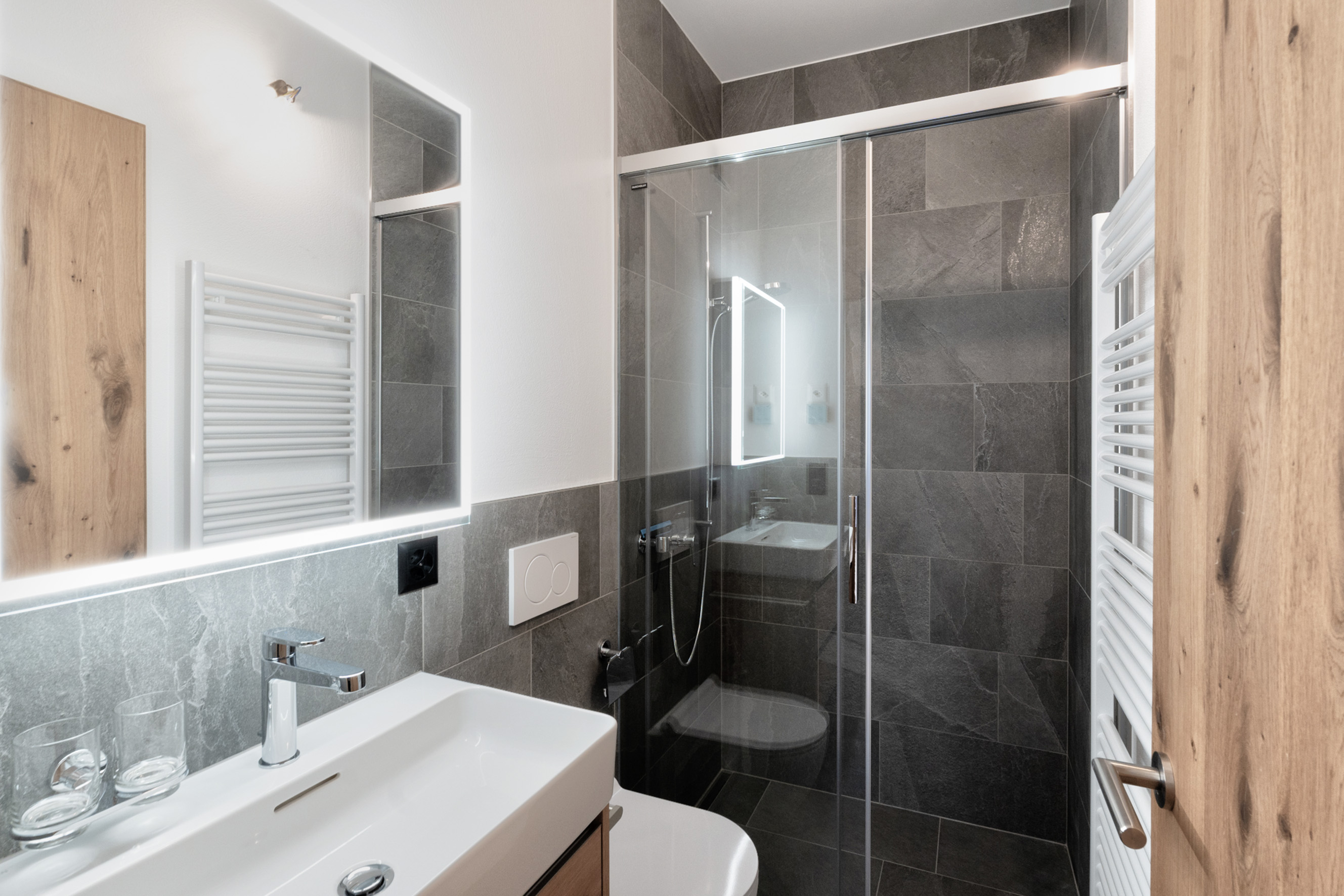 Modernes Badezimmer mit Glasdusche und LED-Spiegel