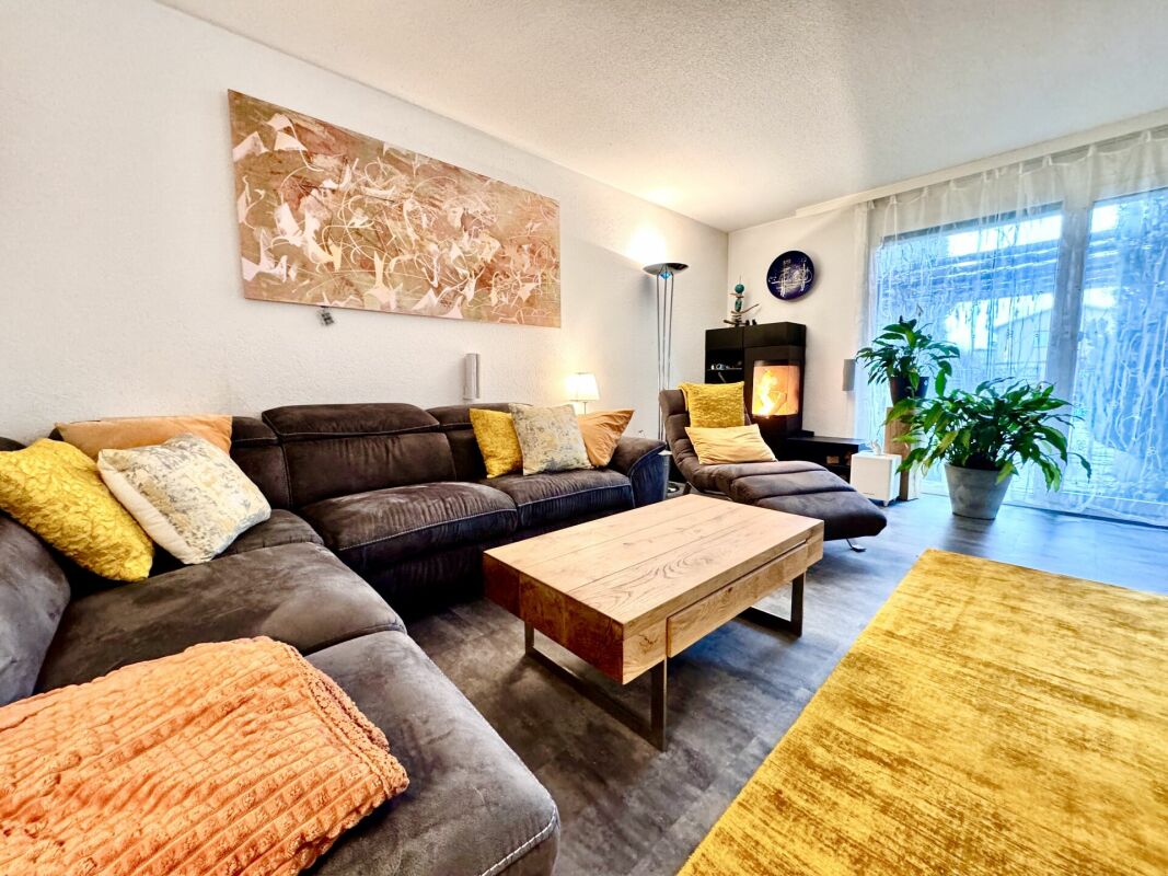 Gemütliches Wohnzimmer mit Kamin und Balkonblick