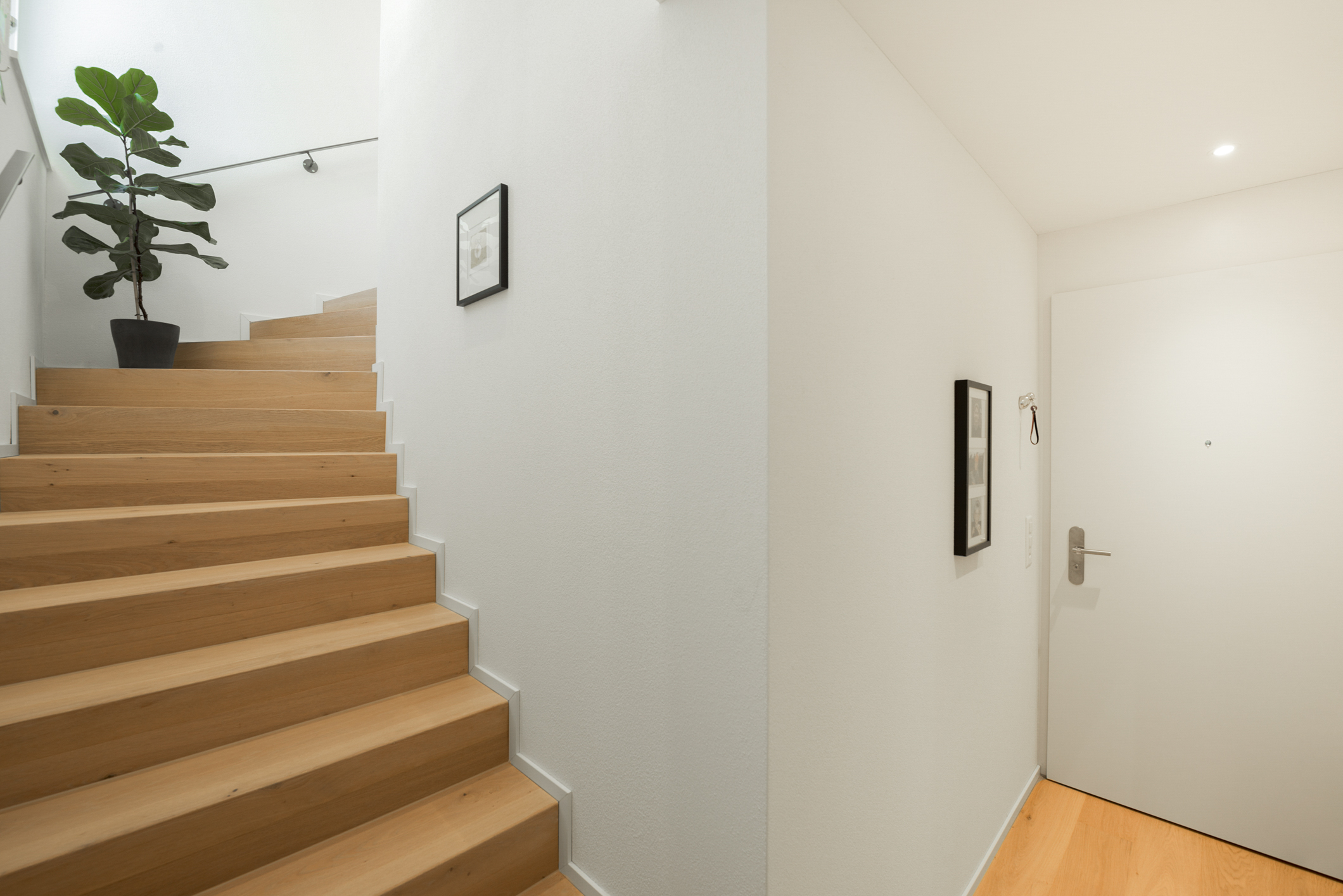 Heller Flur mit Holztreppe