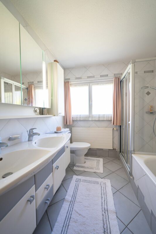 Helles Badezimmer mit Doppelwaschtisch und Dusche
