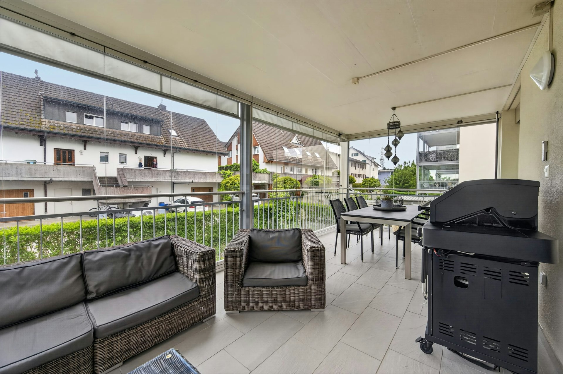 Überdachter Balkon mit Sitzgruppe und Grill