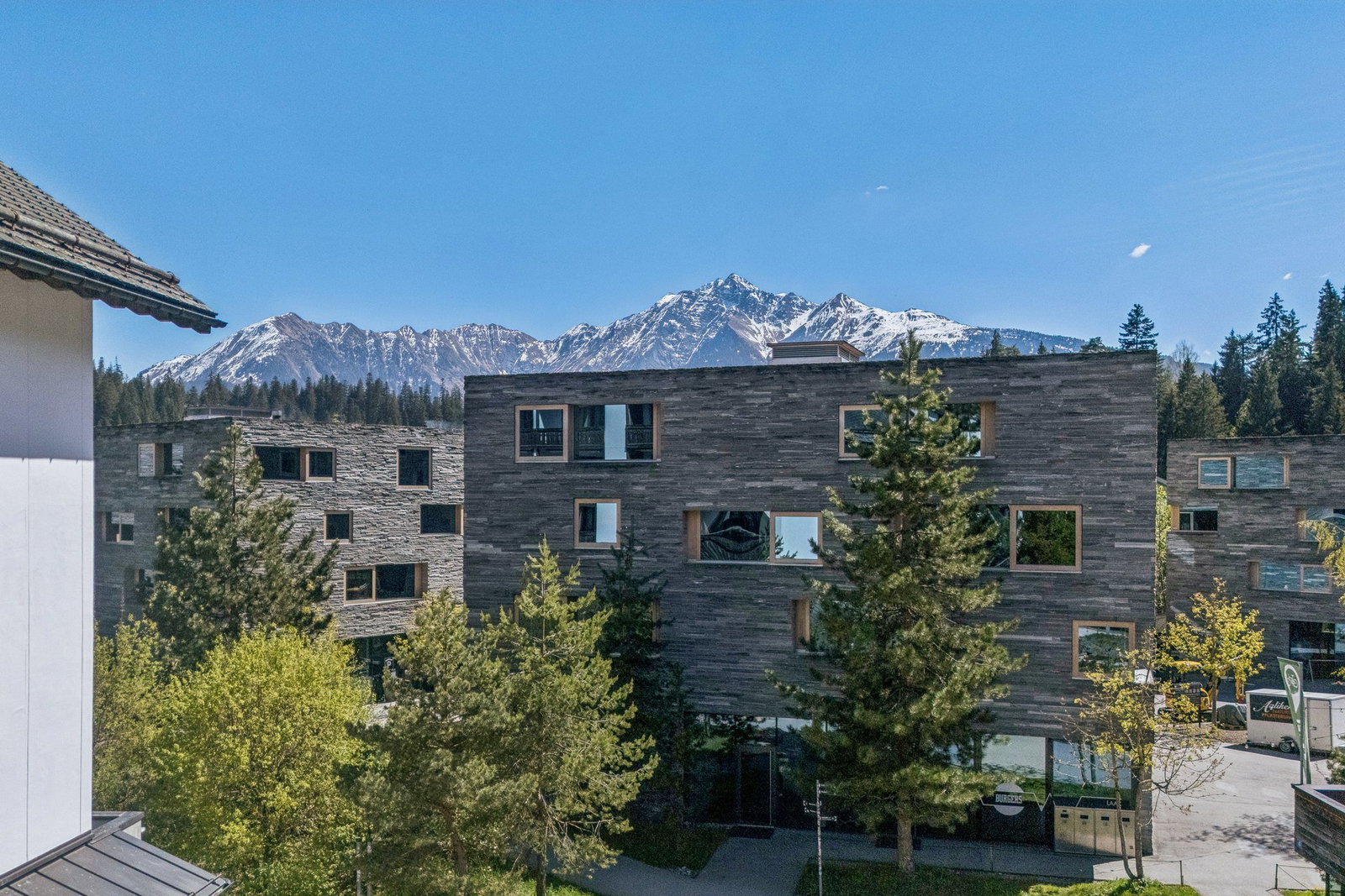 Außenansicht eines modernen Gebäudekomplexes mit Bergkulisse