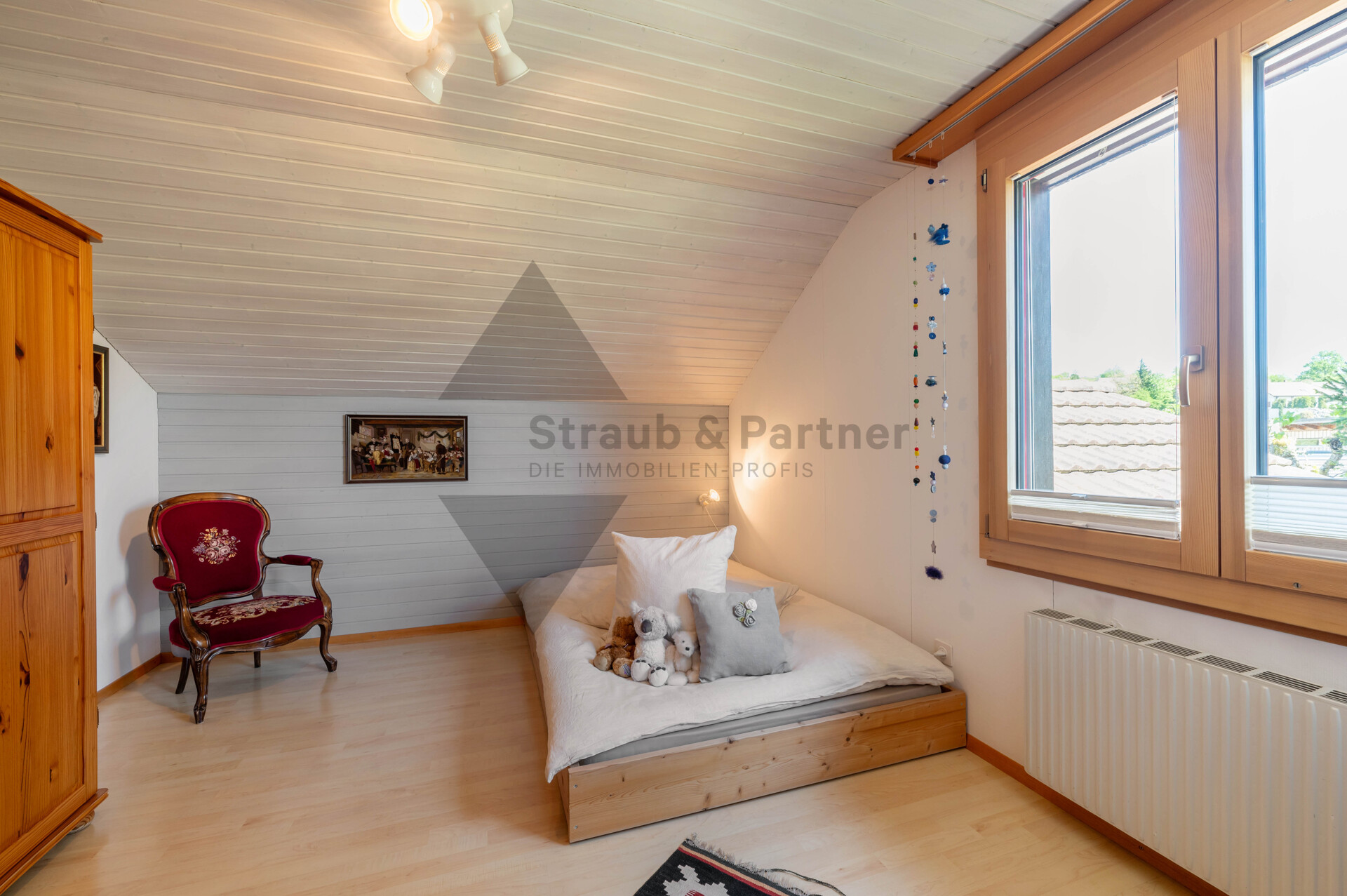 Gemütliches Dachzimmer mit Bett und Fensterbank