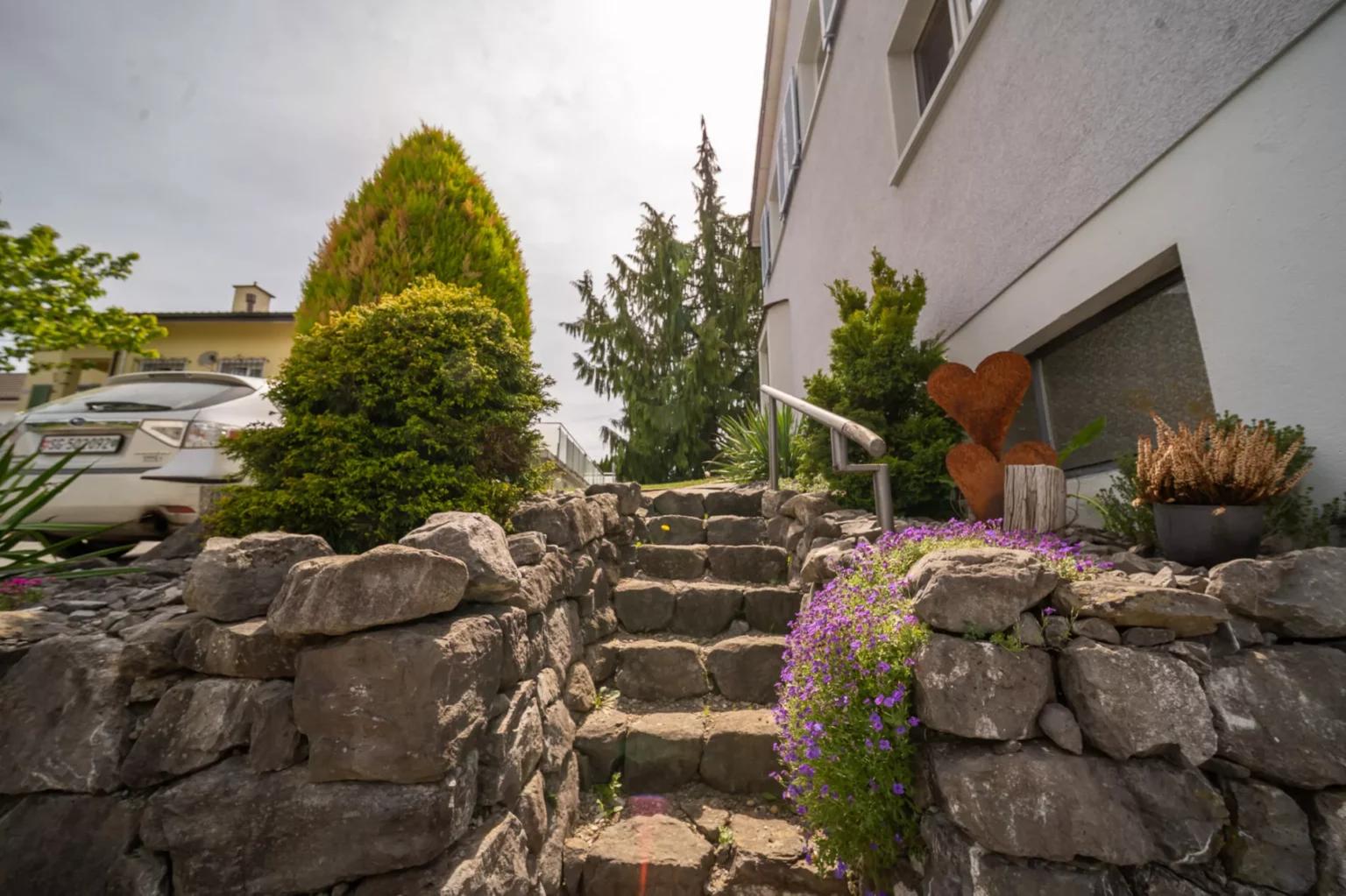 Eingangsbereich mit Steintreppe und Gartenbepflanzung