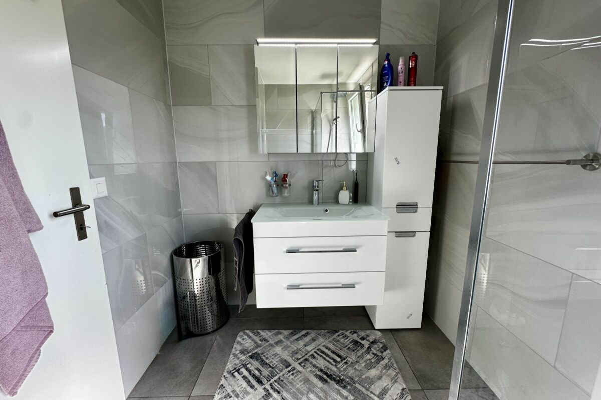 Modernes Badezimmer mit Grautönen und weißem Waschtisch