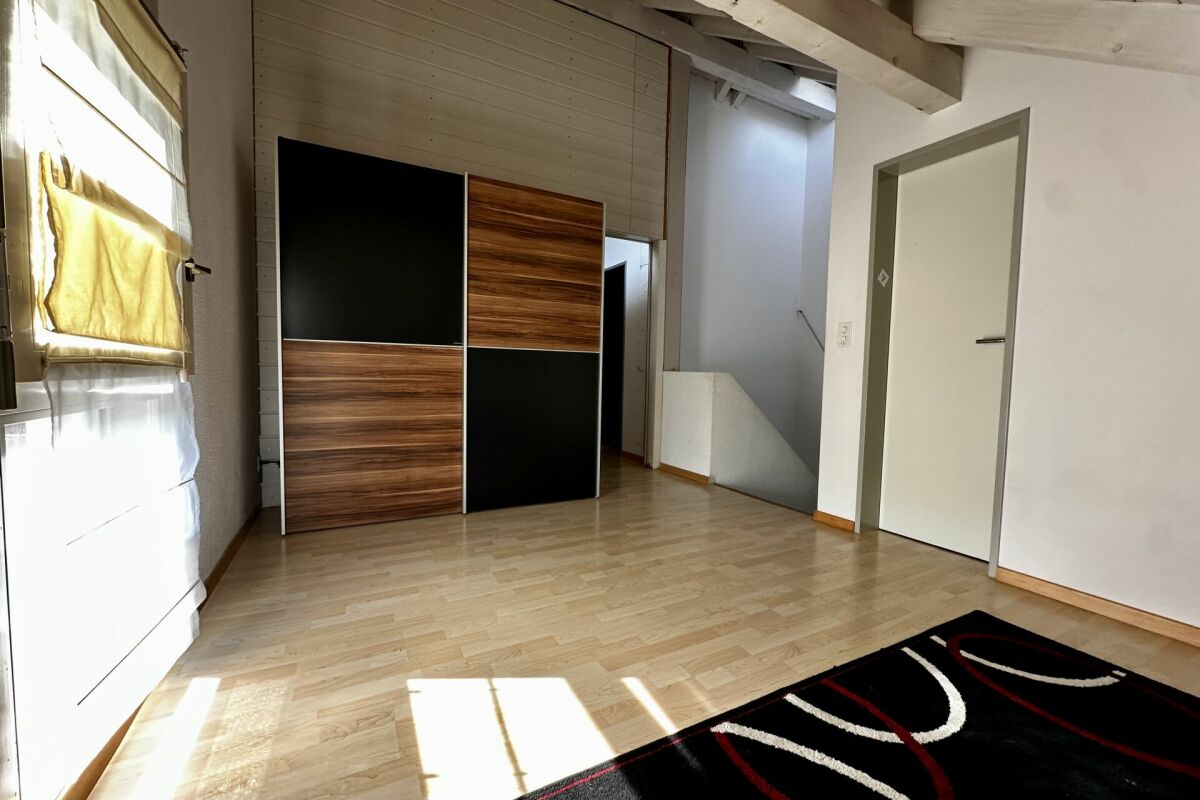 Helles Zimmer mit Holzoptik und Einbauschrank