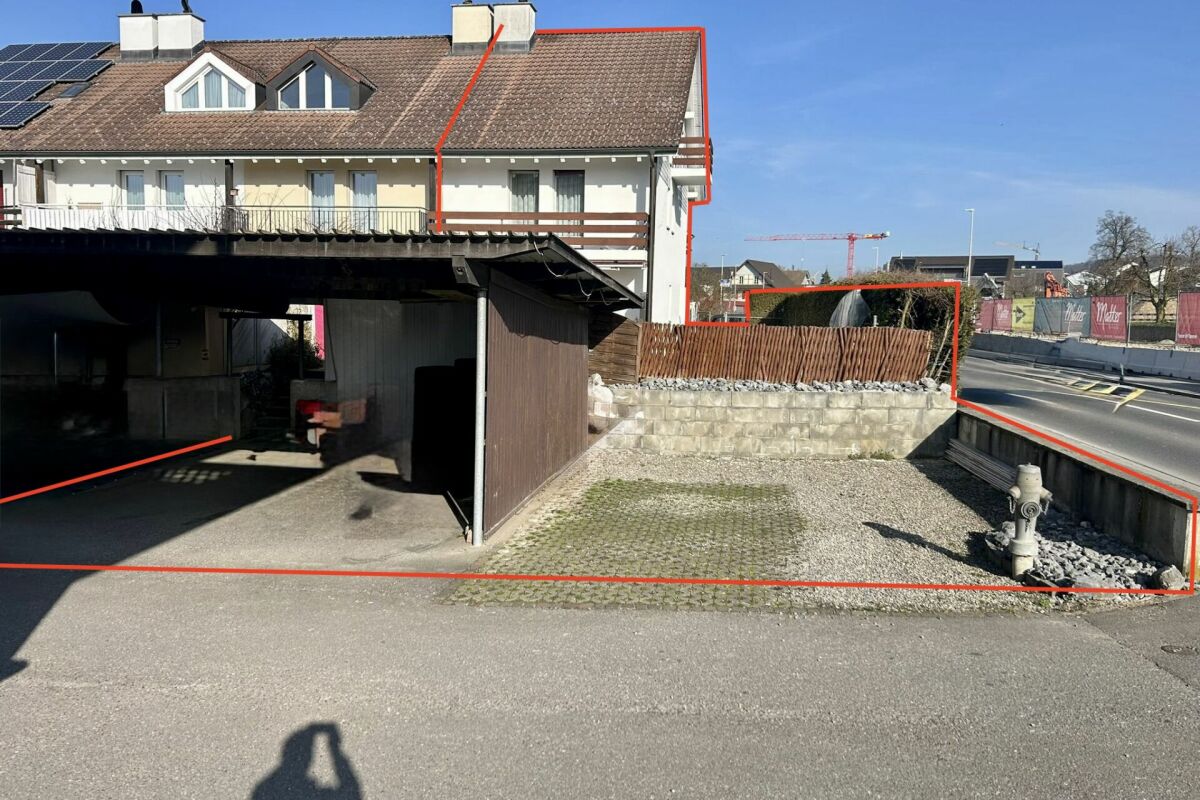 Außenansicht eines Wohnhauses mit Carport und Straßenrand