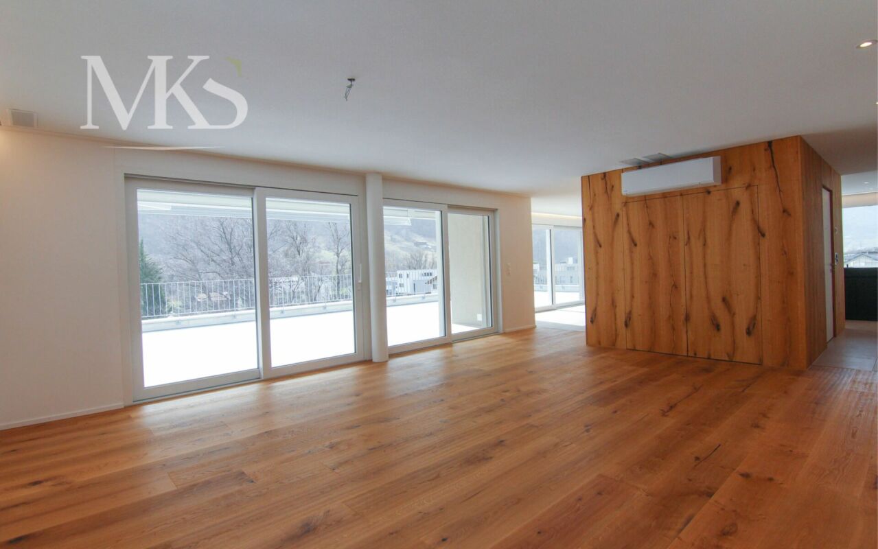 Großer leerer Wohnbereich mit Terrasse und Holzverkleidung