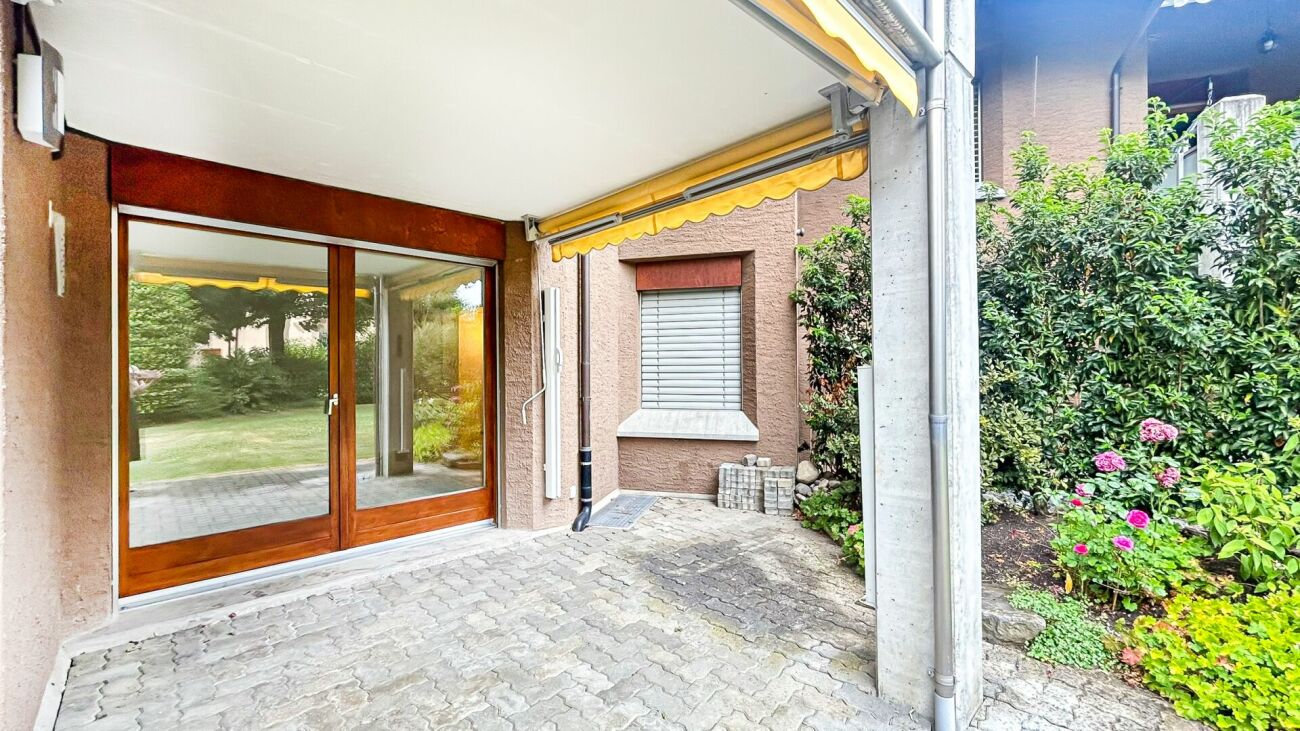 Überdachte Terrasse mit Holz-Schiebetür und Gartenblick