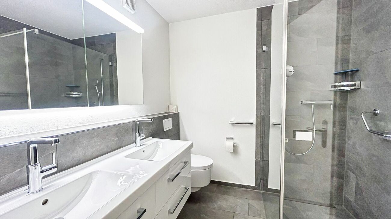 Modernes Badezimmer mit Doppelwaschtisch und Glasdusche
