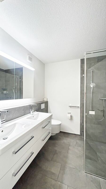 Modernes Badezimmer mit Doppelwaschtisch und Glasdusche