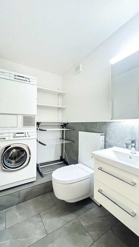Modernes Badezimmer mit Waschtisch und Waschmaschine