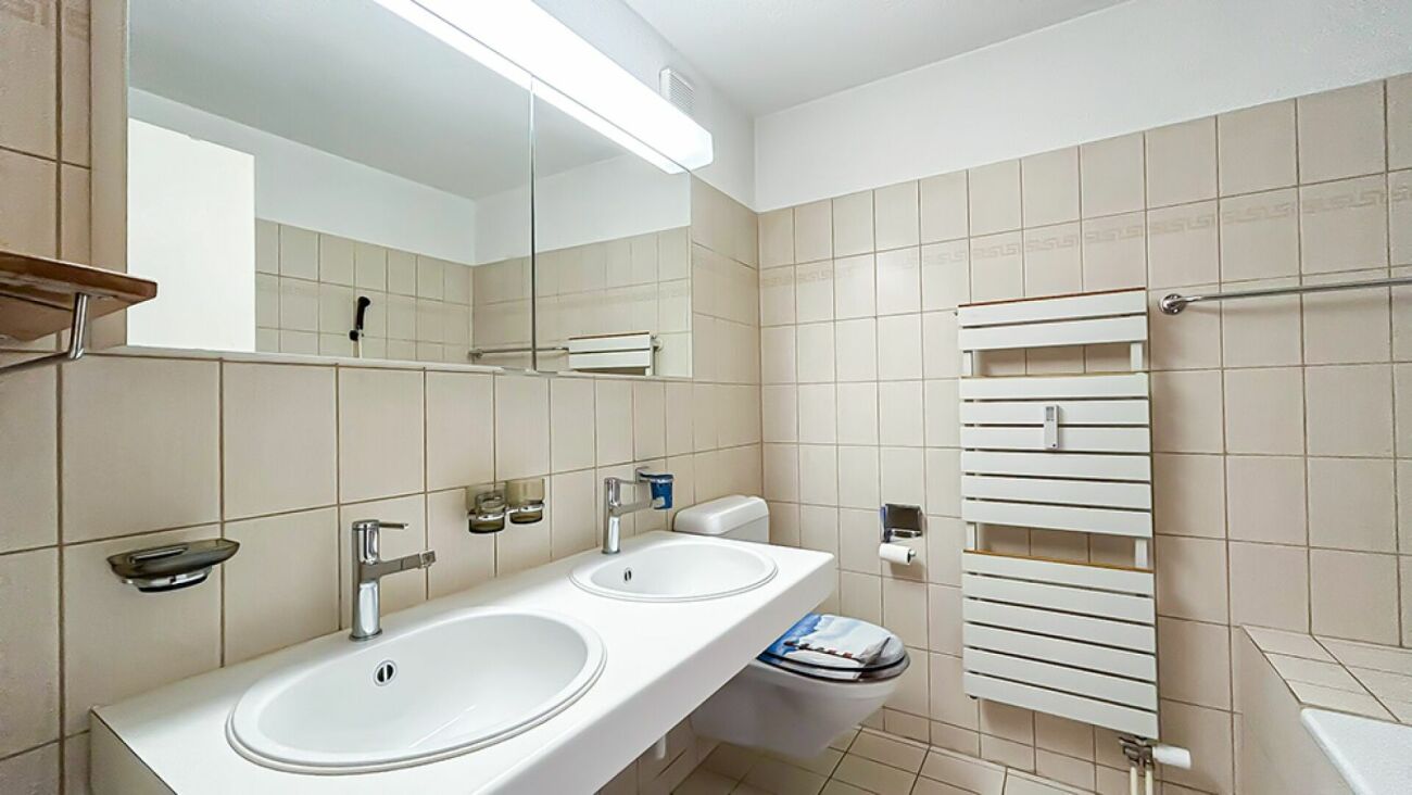 Beige gefliestes Badezimmer mit Doppelwaschtisch