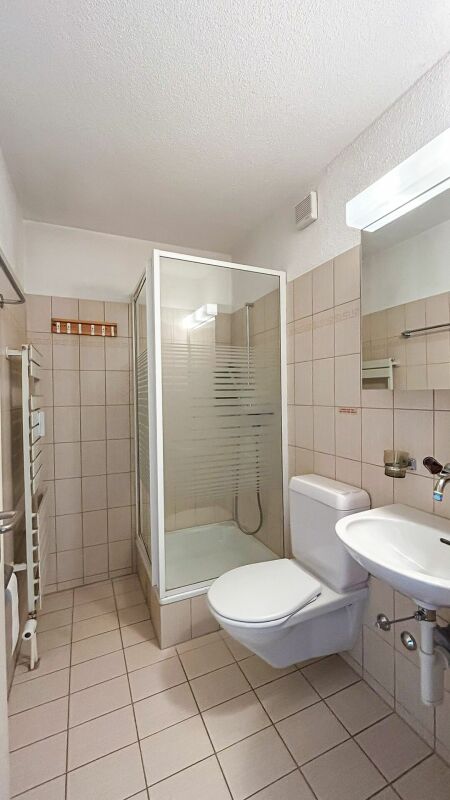 Kleines Badezimmer mit Dusche, WC und Waschbecken