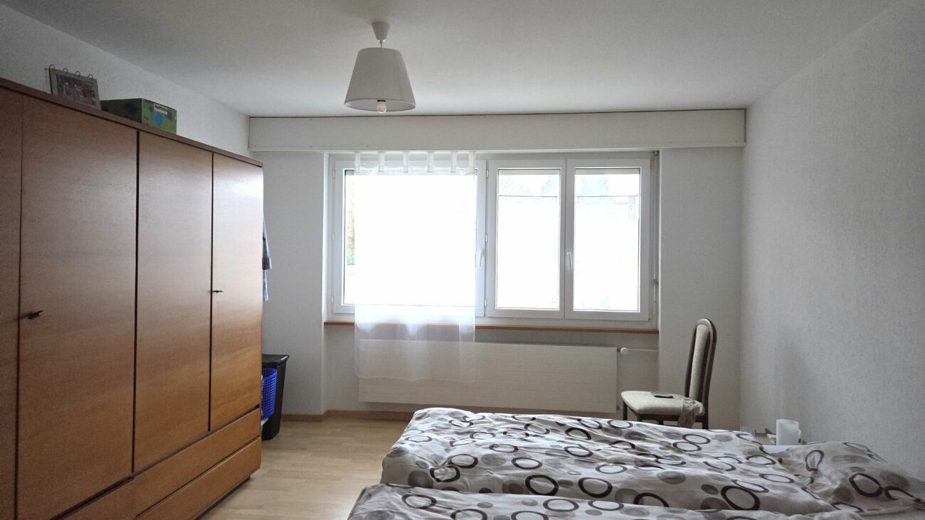 Schlafzimmer mit großem Fenster und Kleiderschrank