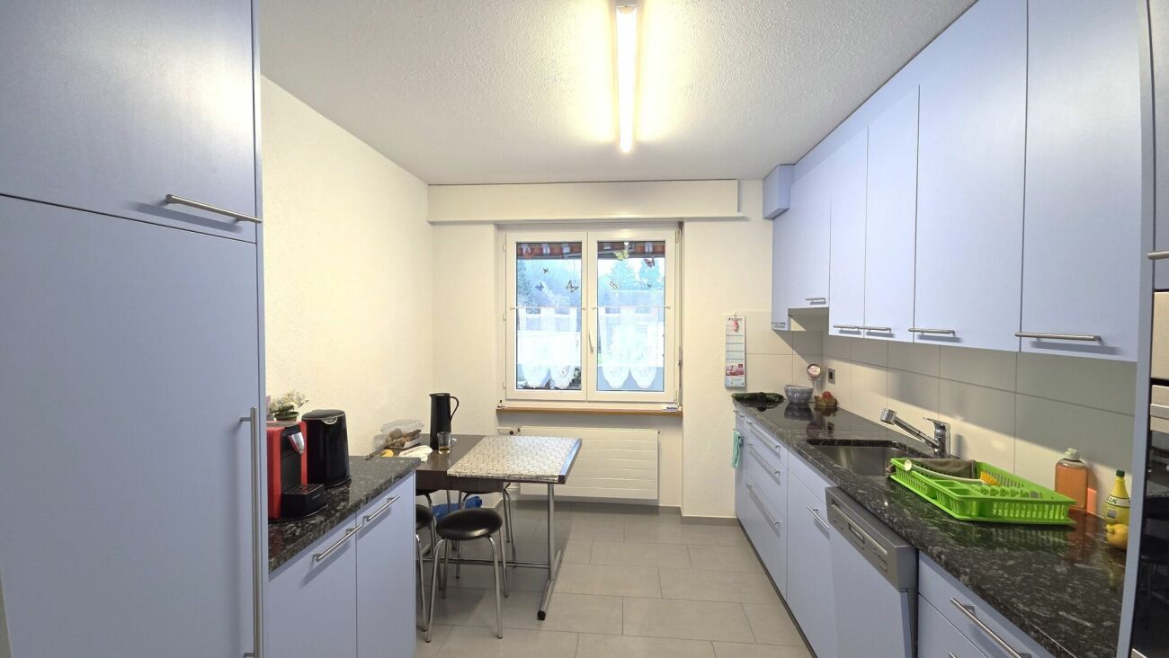 Helle Einbauküche mit Arbeitsbereich und Fenster