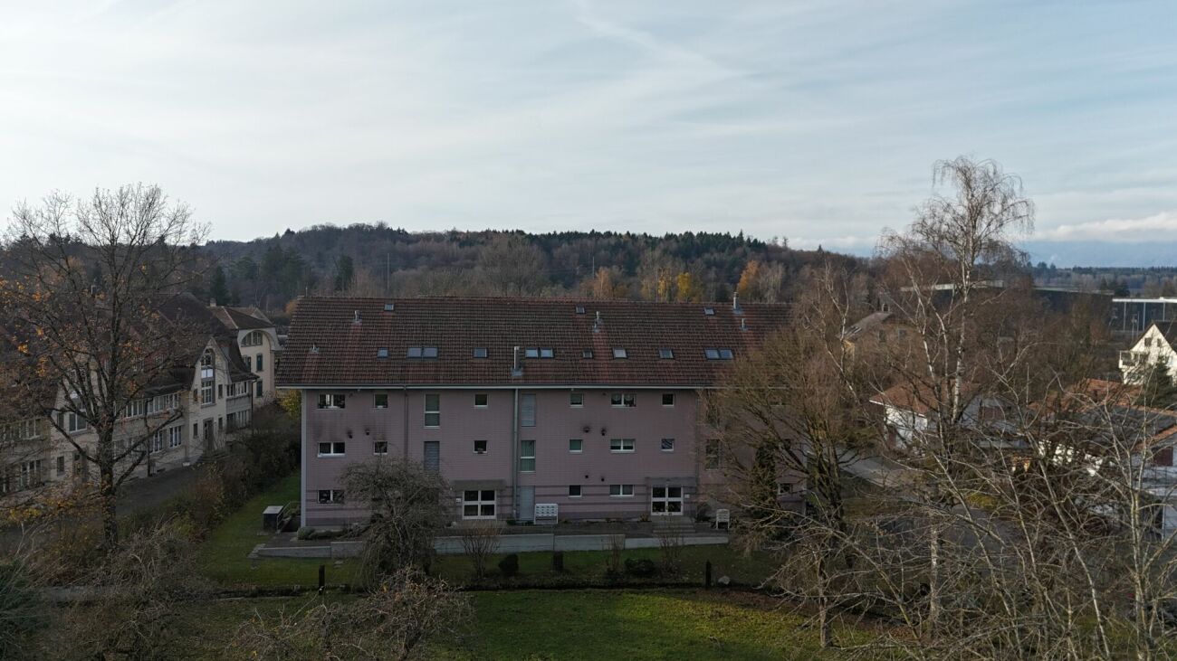 Wohngebäude mit Walmdach in grüner Umgebung