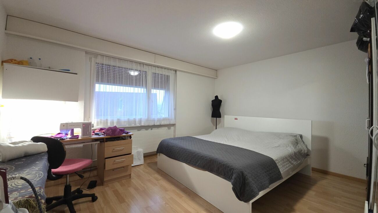 Schlafzimmer mit Bett und Arbeitsbereich