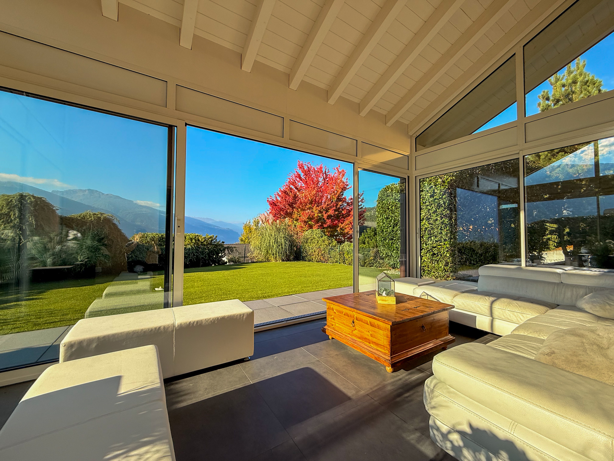 Heller Wohnraum mit Panoramafenstern und Gartenblick