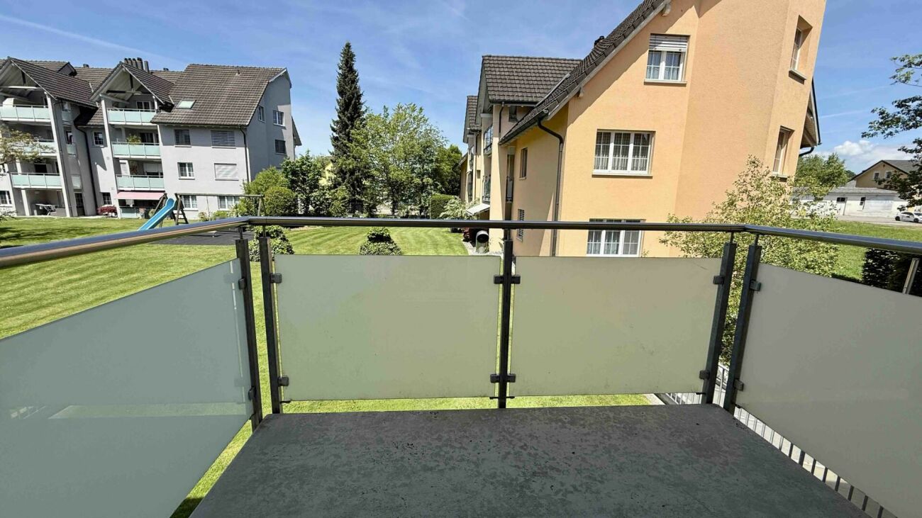 Balkon mit Blick auf Wohnanlage und Grünfläche