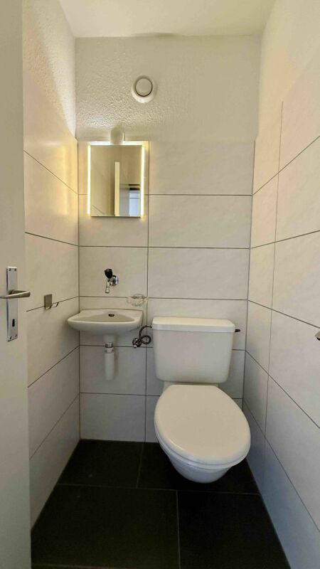 Gäste-WC mit Wand-WC und kleinem Waschbecken