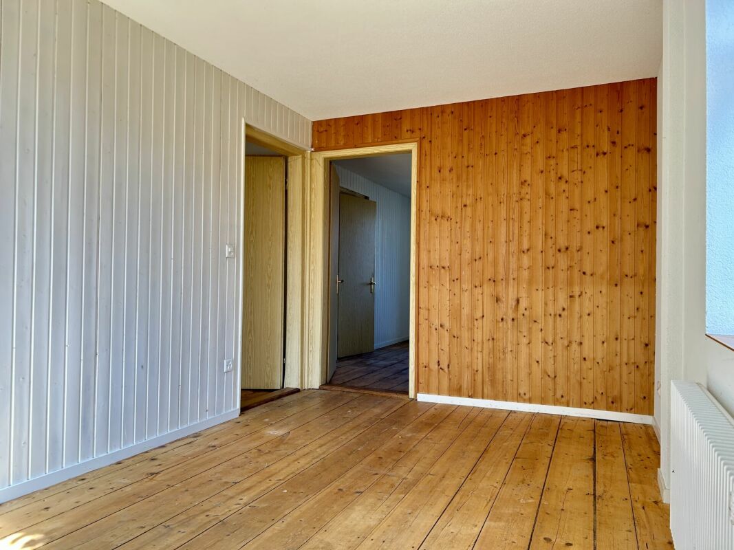 Leerer Raum mit Holzvertäfelung und Dielenboden