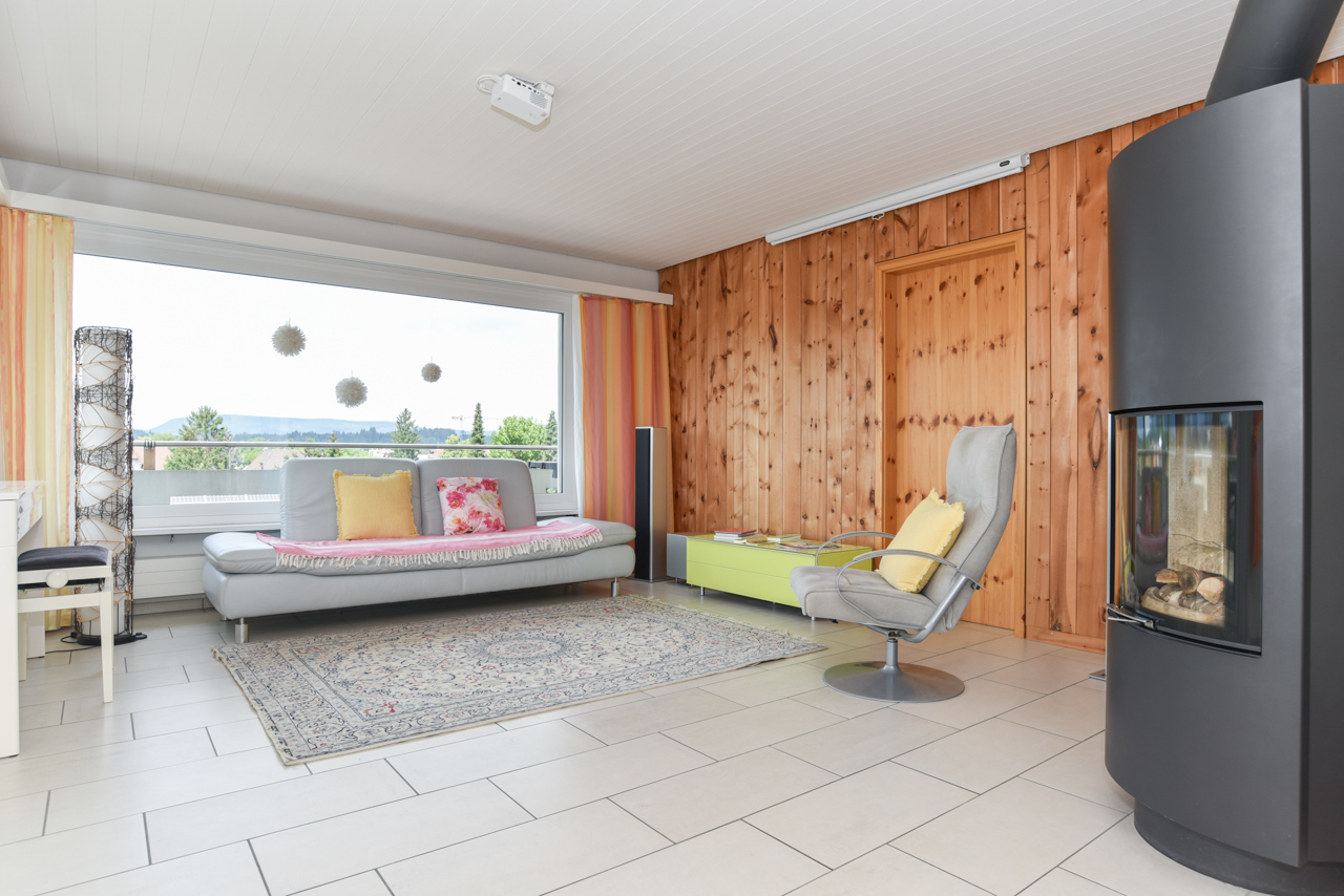 Helles Wohnzimmer mit Holzwand und Kamin