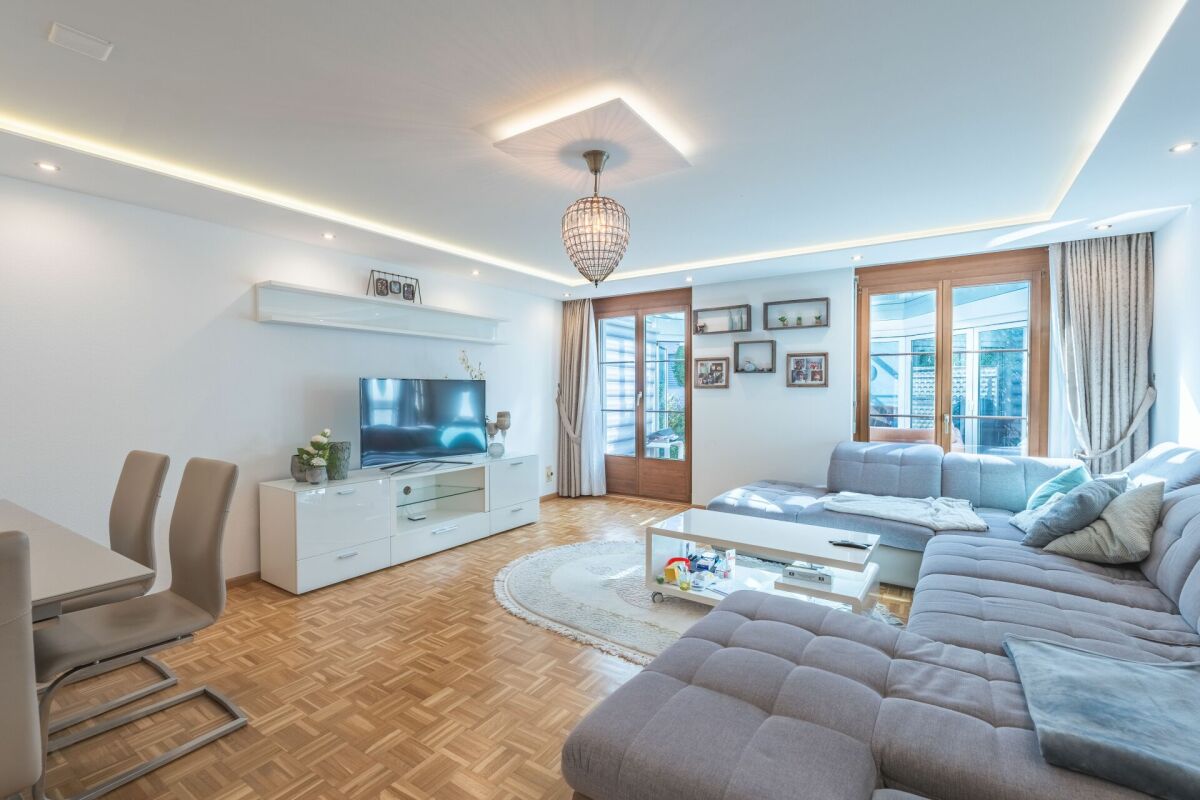 Helles Wohnzimmer mit großer Eckcouch und Balkonzugang