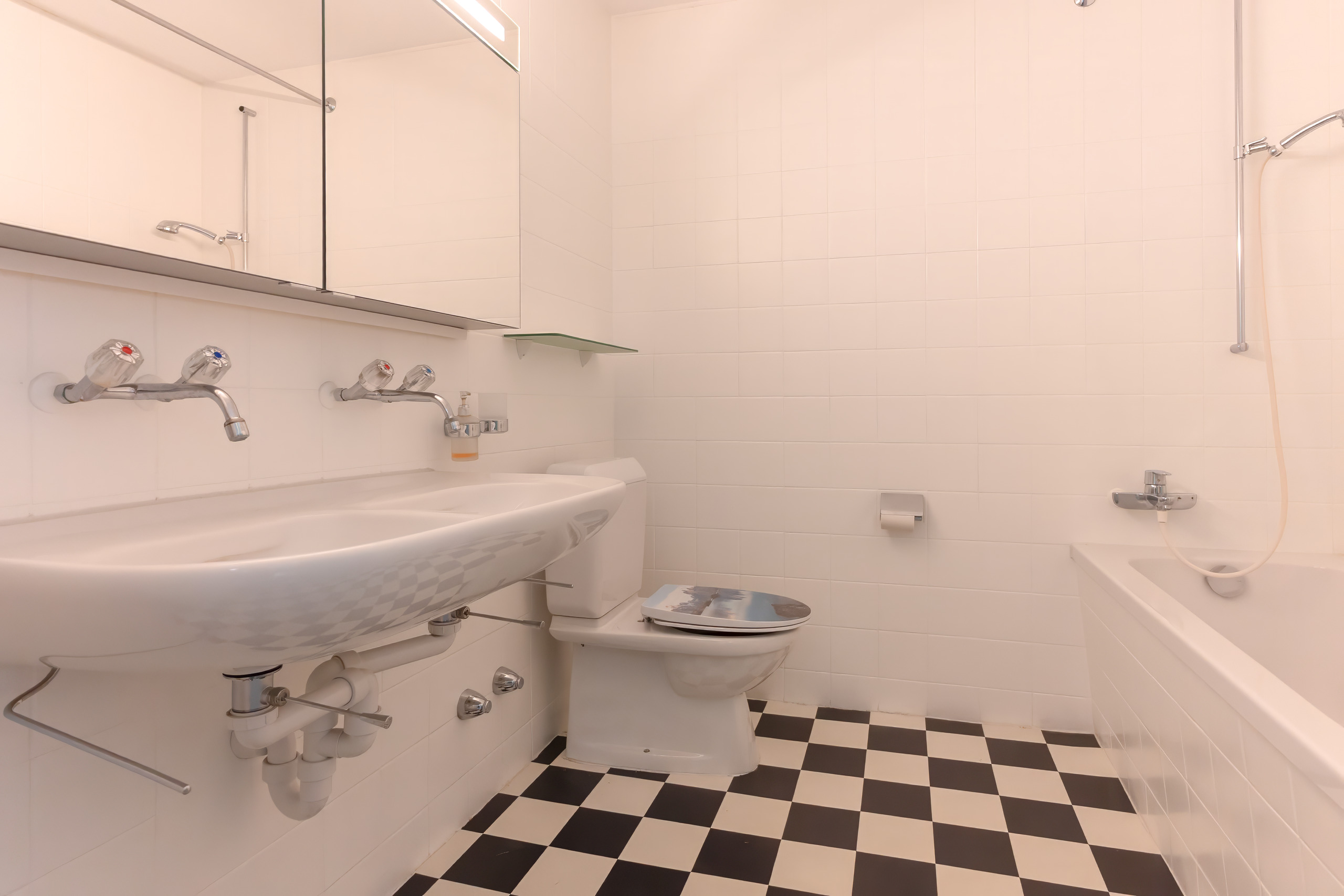Kleines weißes Badezimmer mit checkered Boden