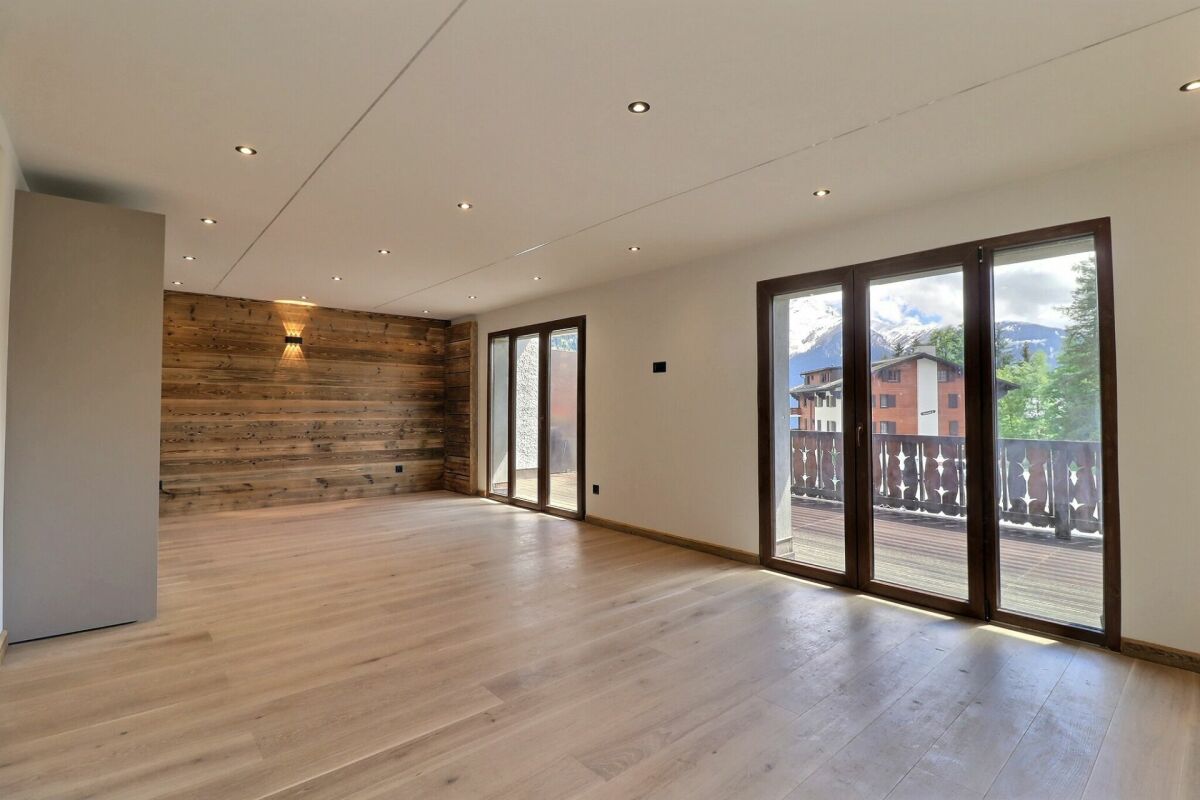 Großer leerer Wohnraum mit Balkon und Bergblick