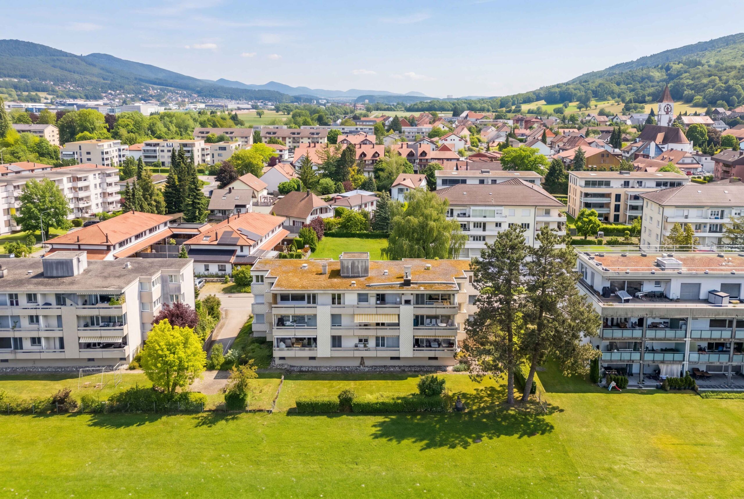 Luftaufnahme eines Wohnviertels mit Alpenpanorama