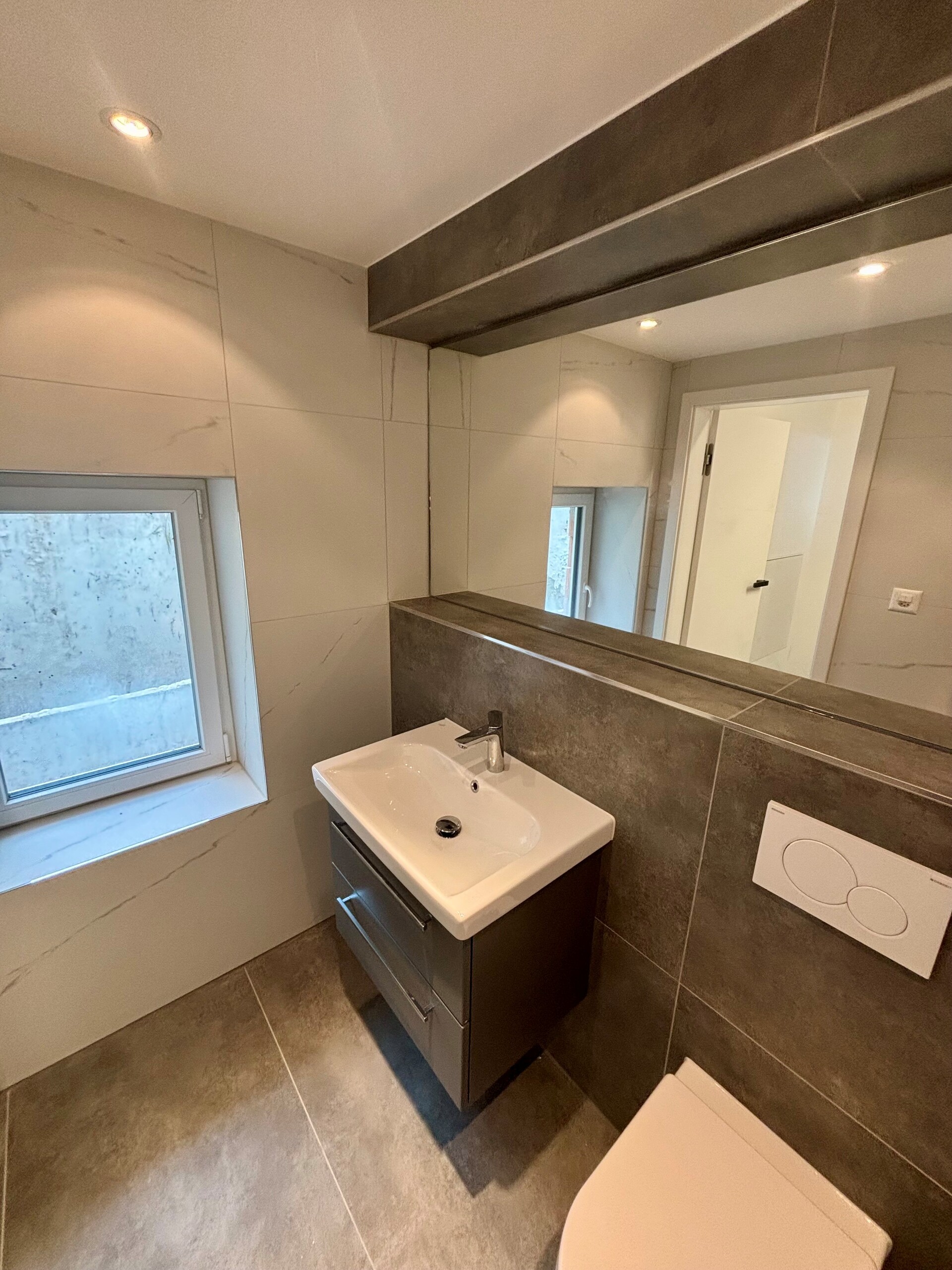 Modernes Badezimmer mit Fenster und Spiegel