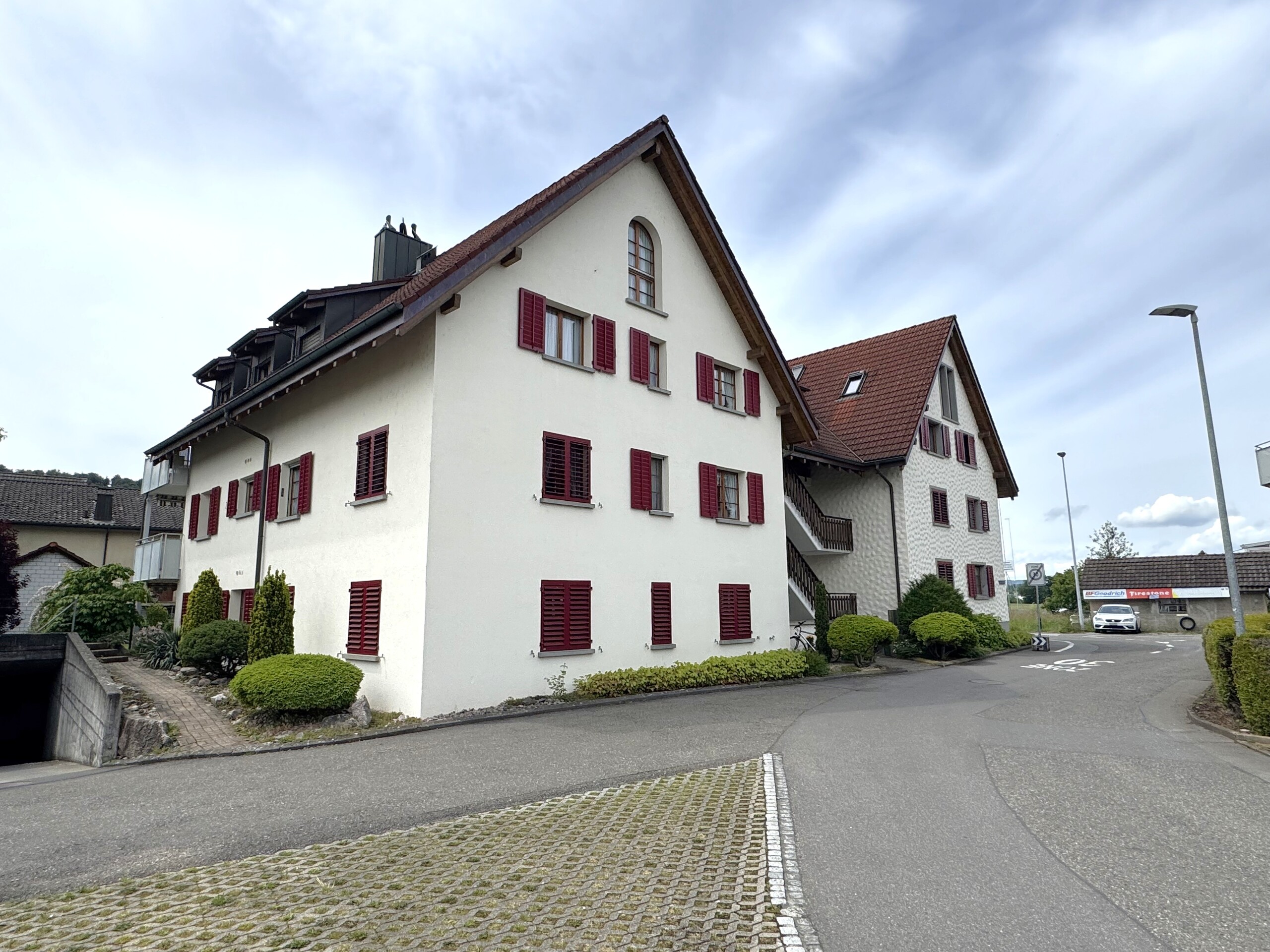 Wohnhaus mit Satteldach und roten Fensterläden