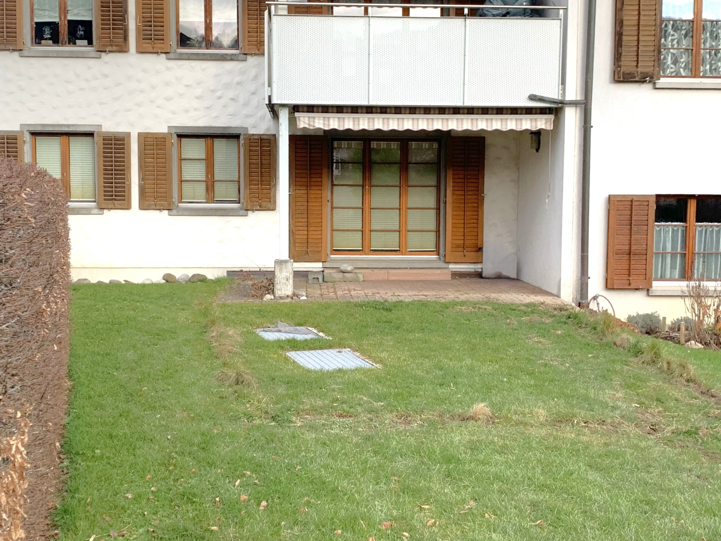 Außenansicht eines Wohnhauses mit Balkon und Garten