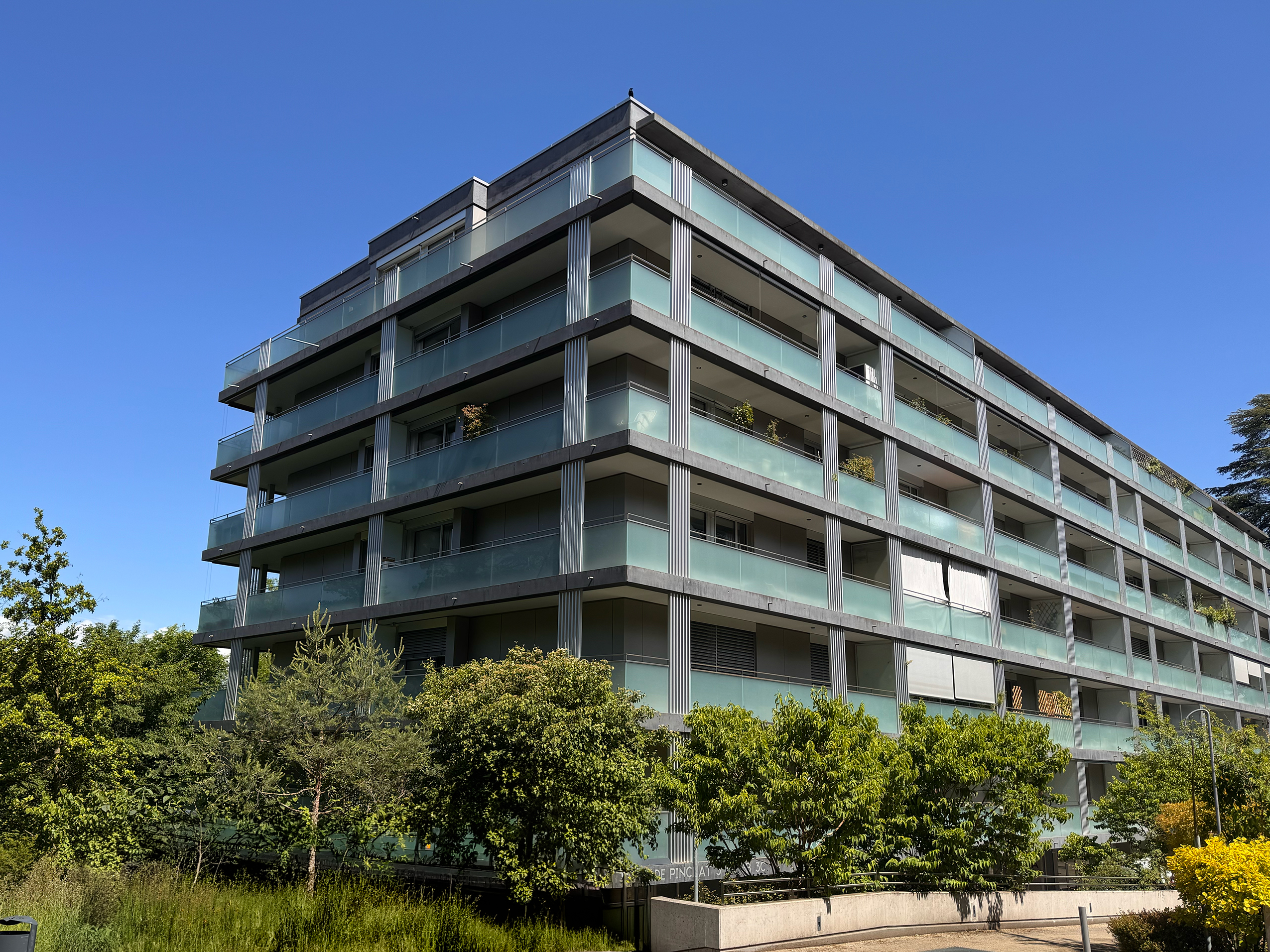 Modernes Mehrfamilienhaus mit Glasbalkonen