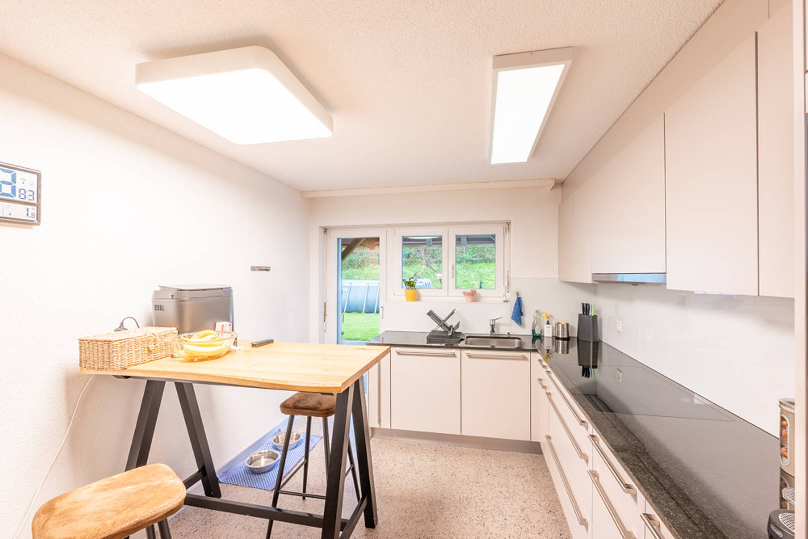 Moderne, schmale Küche mit Fenster zum Garten