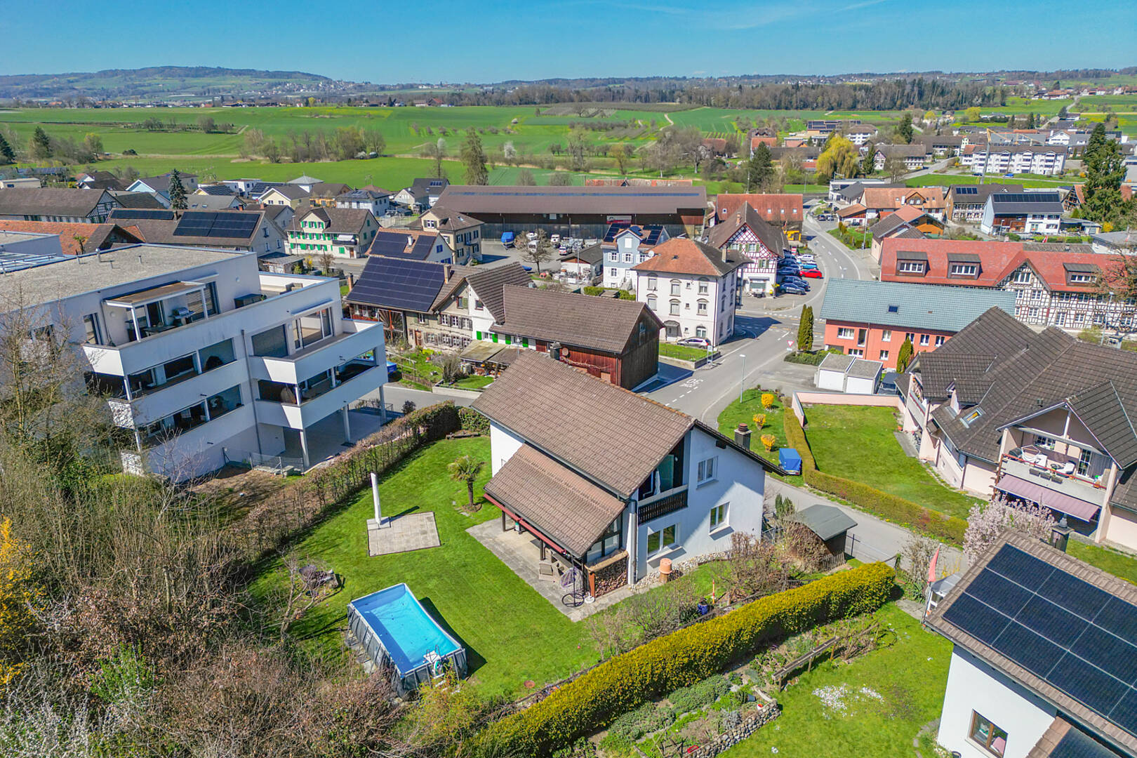 Luftaufnahme eines Wohngebiets mit Einfamilienhaus und Pool