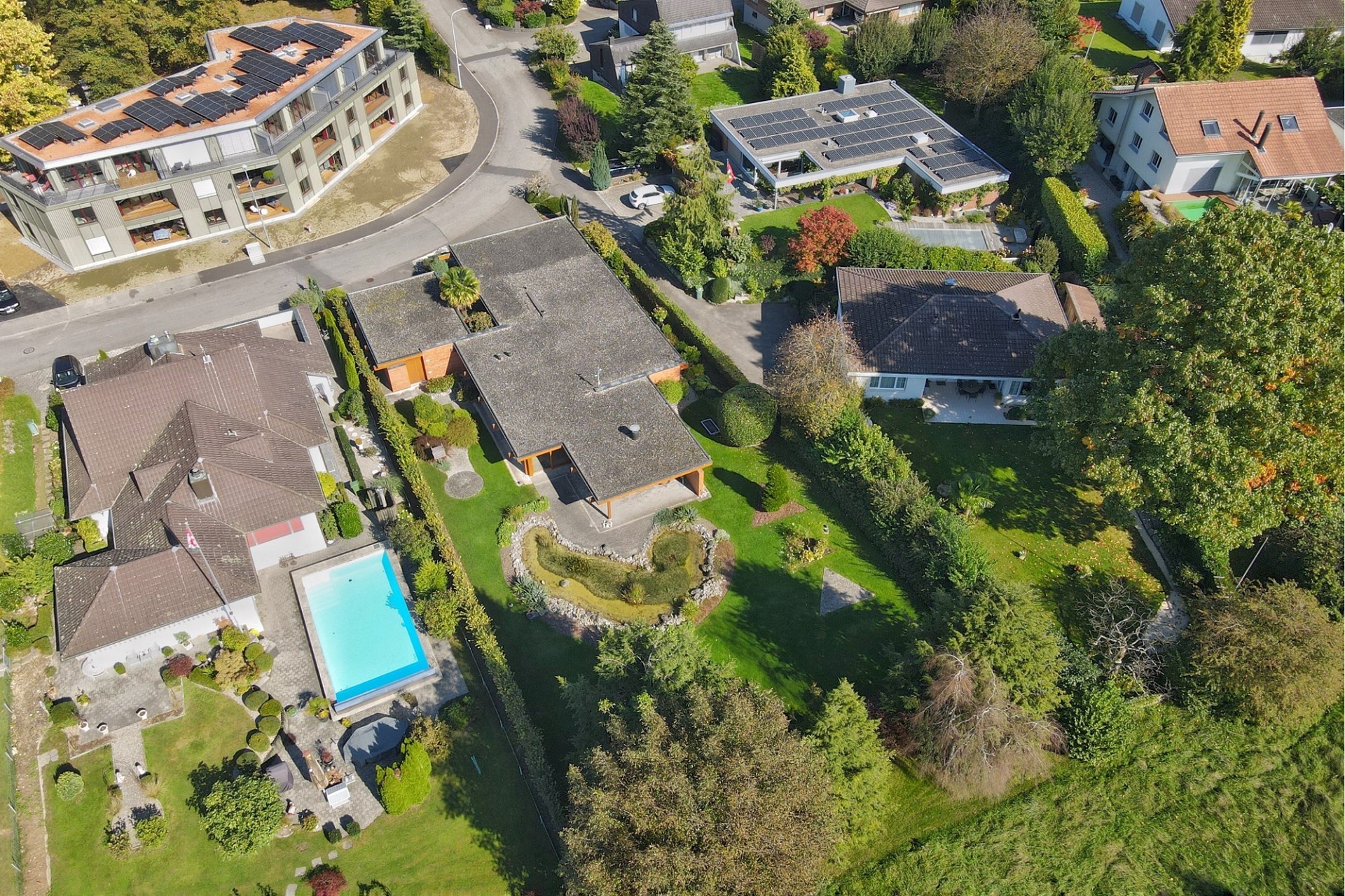 Luftaufnahme einer Wohnsiedlung mit Pool und Solardächern