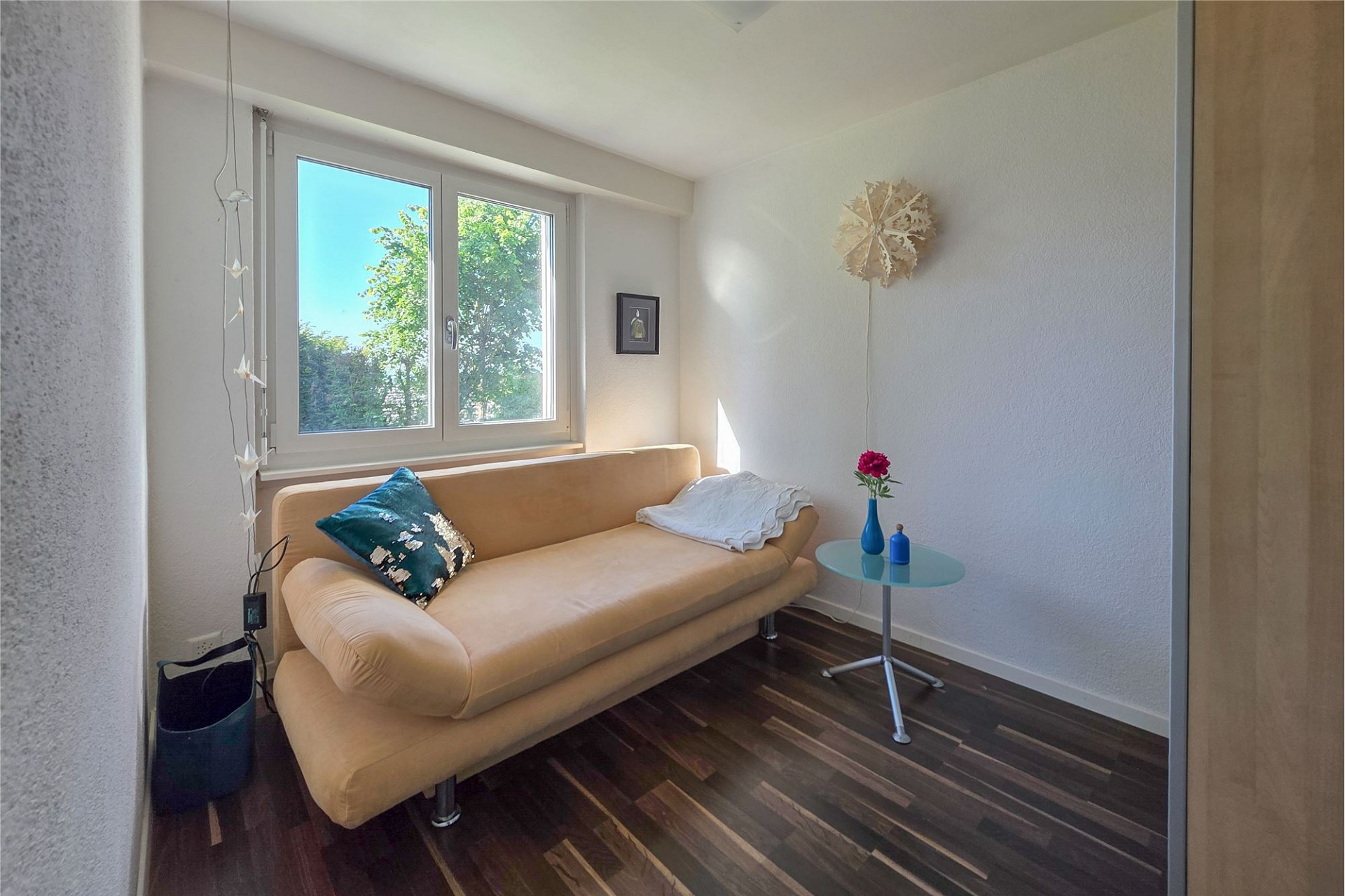 Kleines helles Zimmer mit Sofa am Fenster