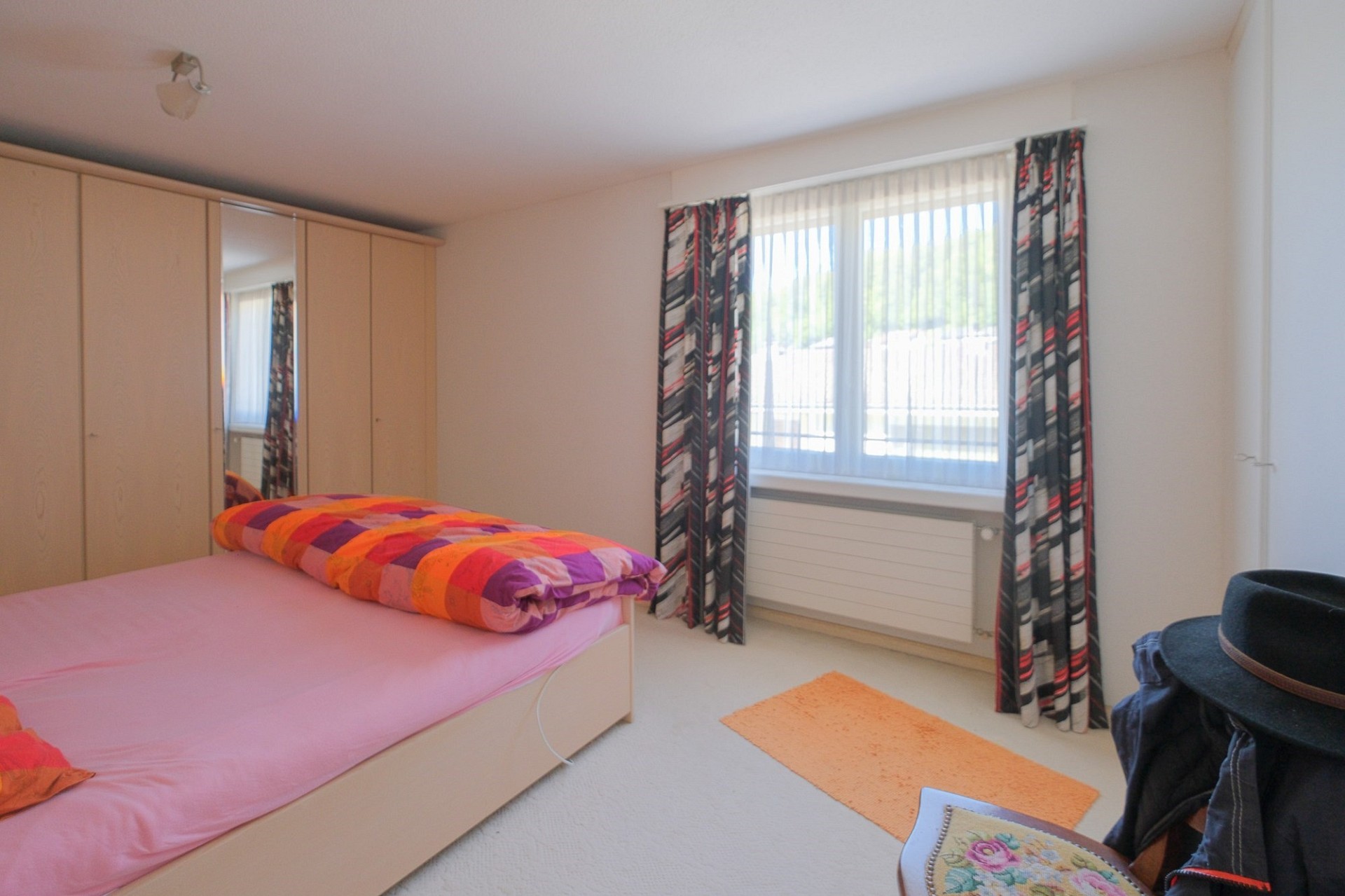 Helles Schlafzimmer mit Doppelbett und Kleiderschrank