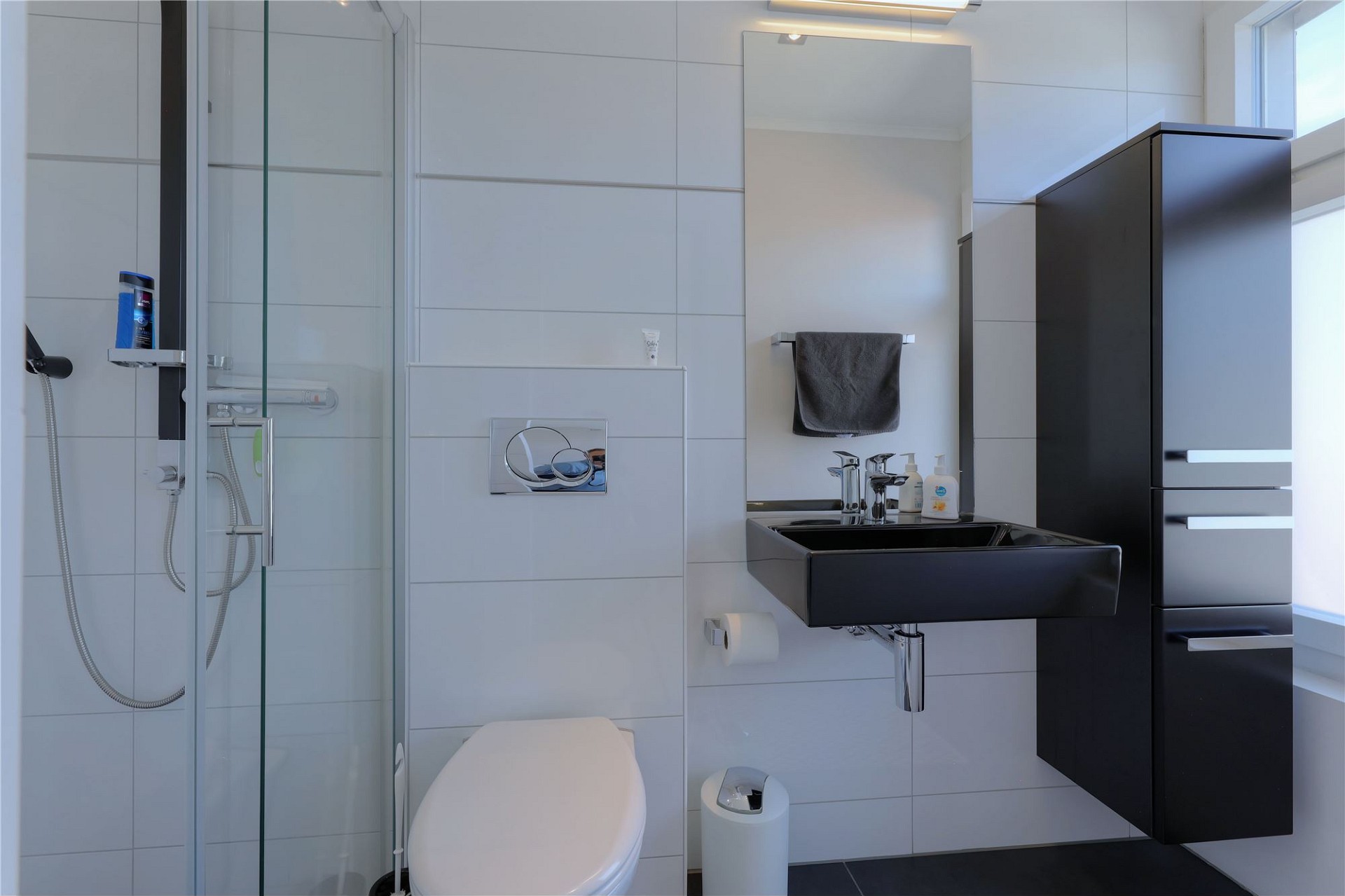 Modernes Bad mit Glasdusche und schwarzem Waschtisch