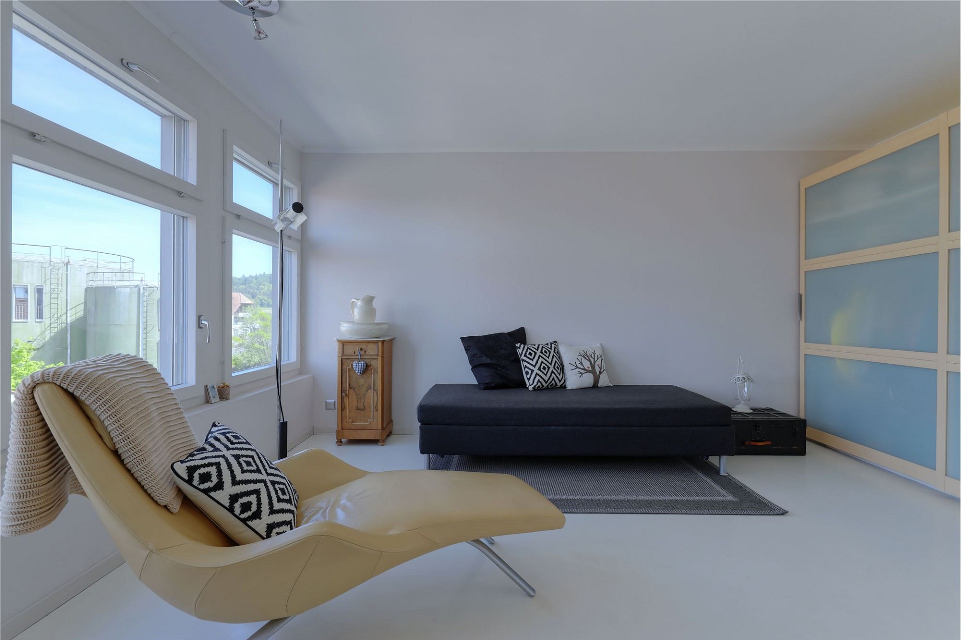 Helles minimalistisches Schlafzimmer mit großen Fenstern