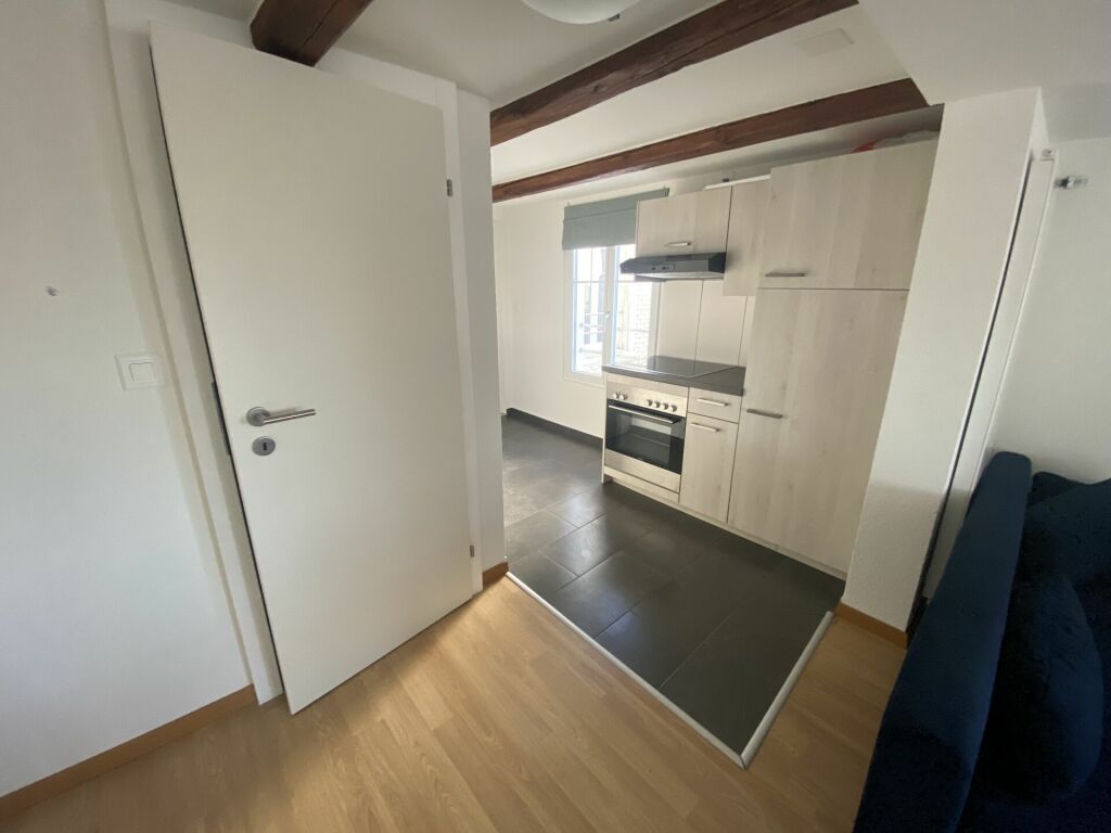 Kompakte Wohnküche mit sichtbaren Holzbalken
